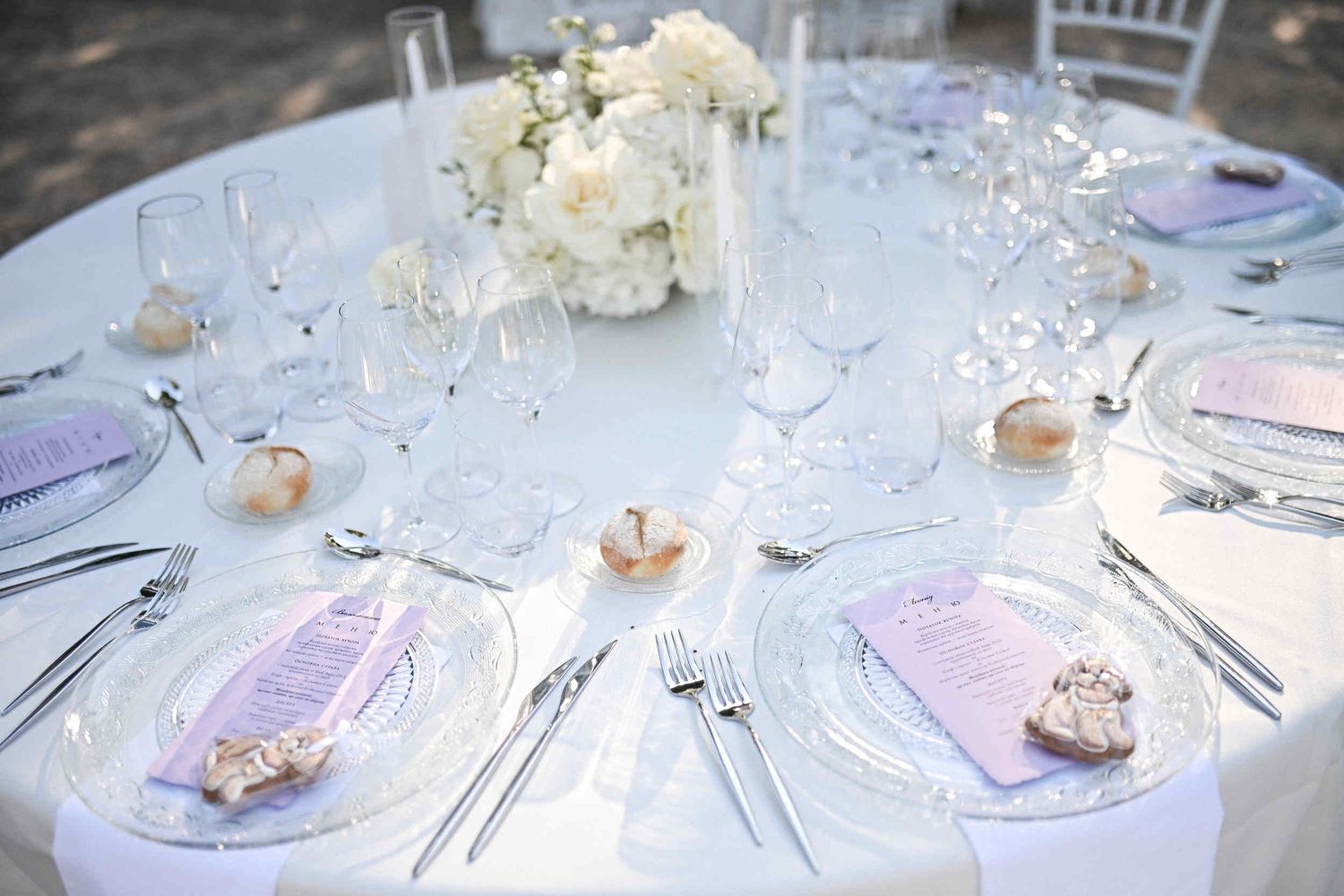Elegant wedding table setting featuring pink menus and dog-shaped gingerbread favors for guests at a Spanish finca.