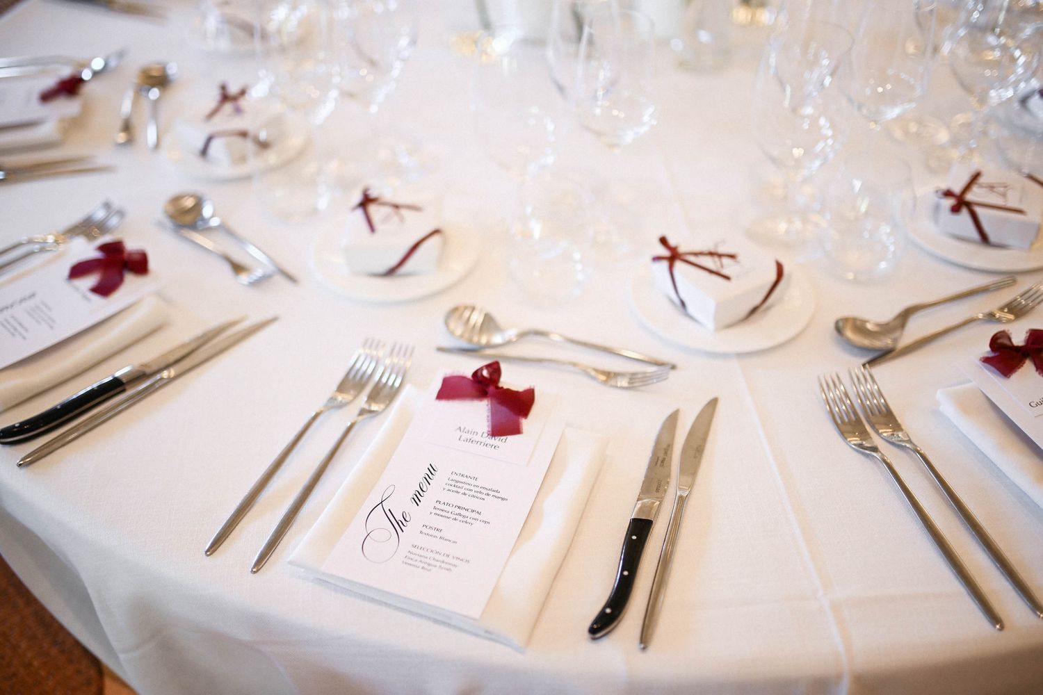 Elegant wedding place setting featuring a printed menu tied with a burgundy ribbon at a Finca del Canónigo reception.