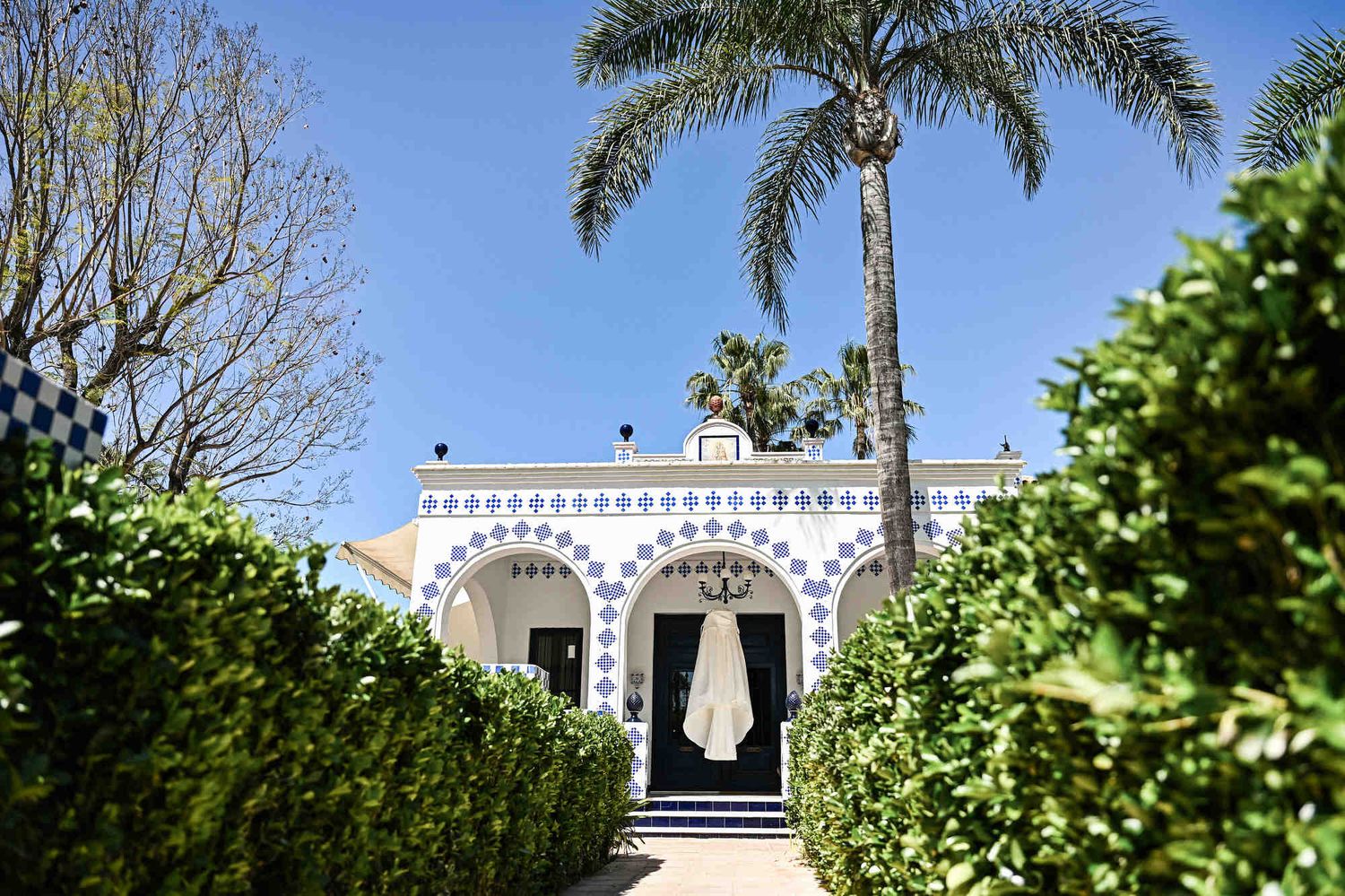 Historic Villa Paula facade with blue tiles and a hanging wedding dress for a destination wedding