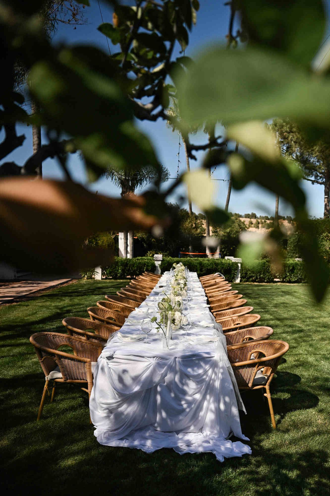 Beautiful outdoor wedding banquet setup on the green lawn under string lights at Villa Paula historic estate