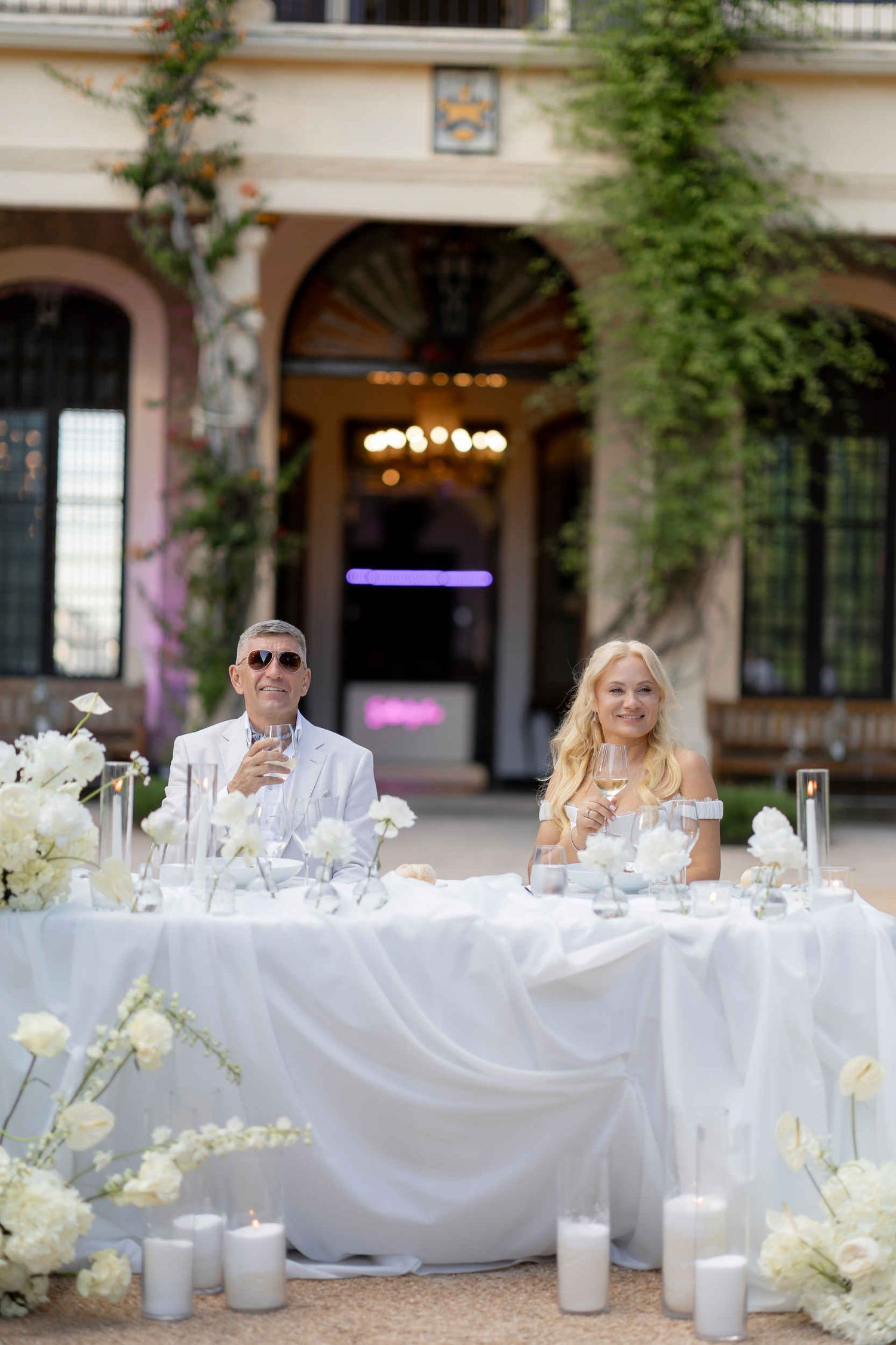 Bride and groom at a white sweetheart table decorated with candles and white flowers in Altea.