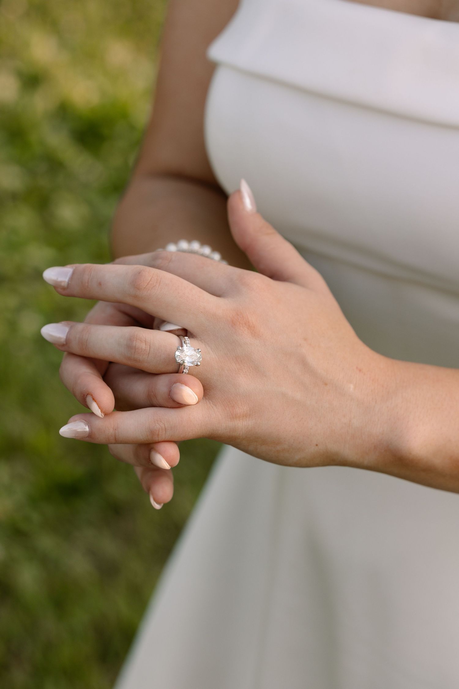 Close-up of bride's hands showing stunning large diamond solitaire engagement ring on wedding day.