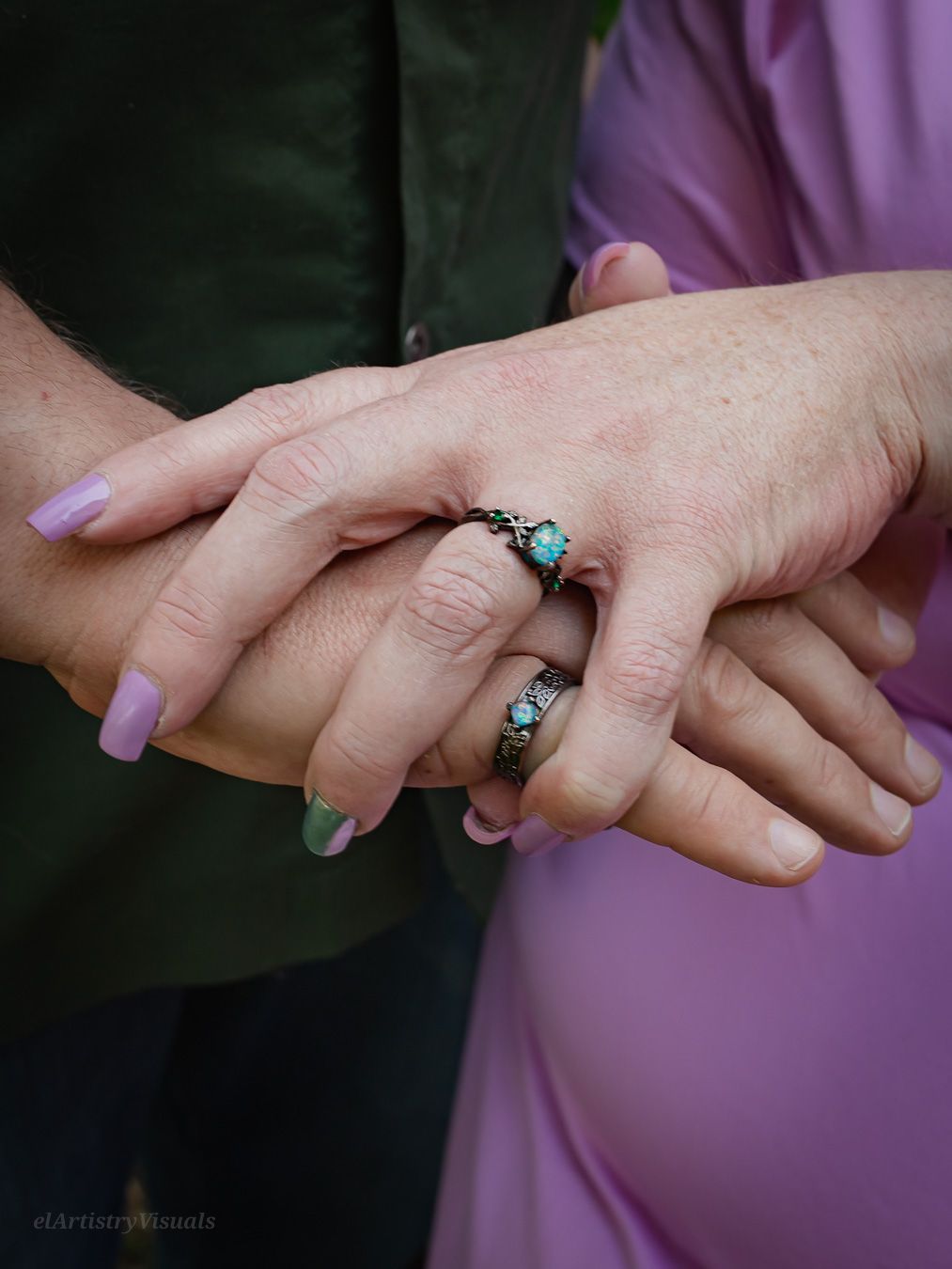 Close-up of two people holding hands showing matching turquoise stone rings, one wearing a purple dress.