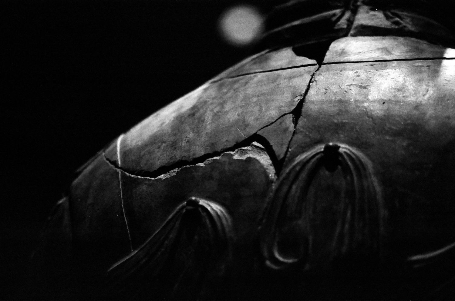 Close-up black and white photo of a cracked and weathered terracotta warrior in China.