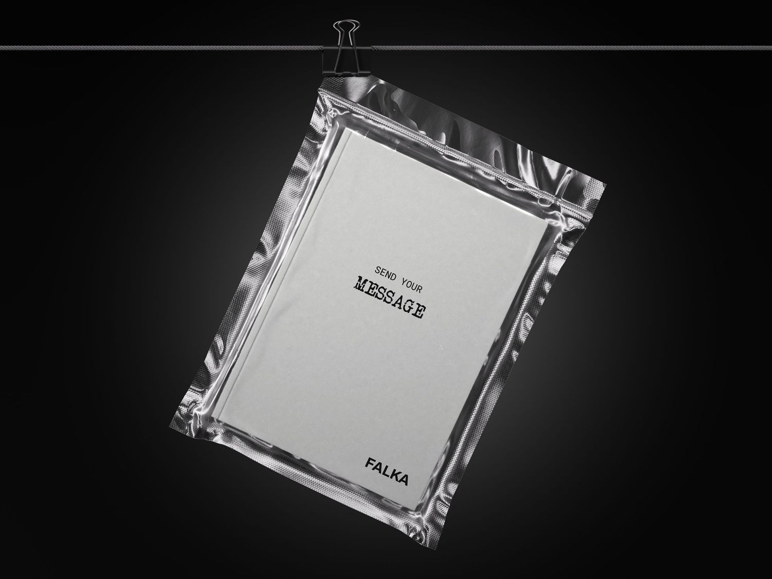 Silver metallic framed card with MESSAGE text hanging from a binder clip on dark background.