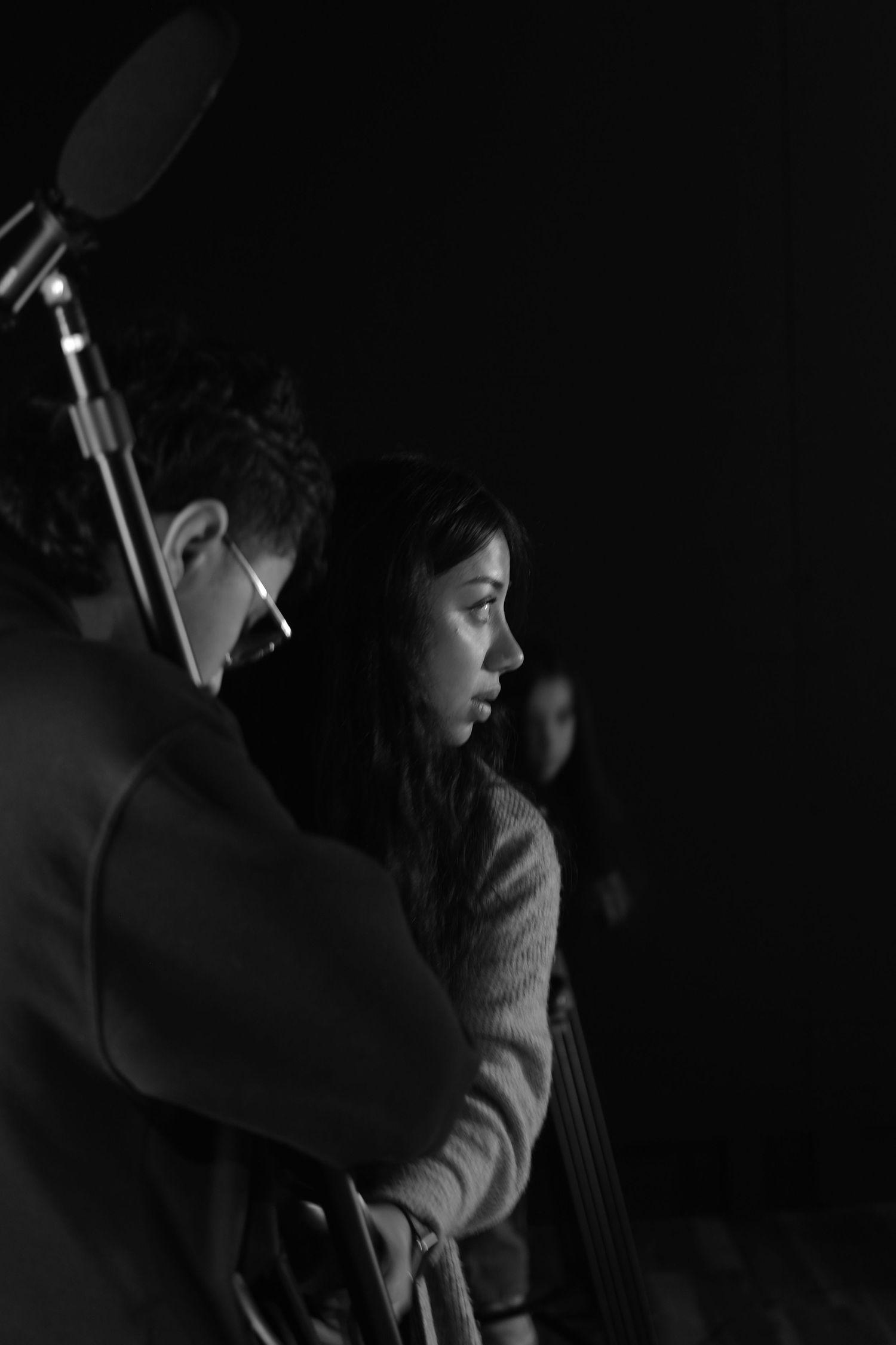 Creative professional acting in gaffer role setting up equipment in preparation for filming