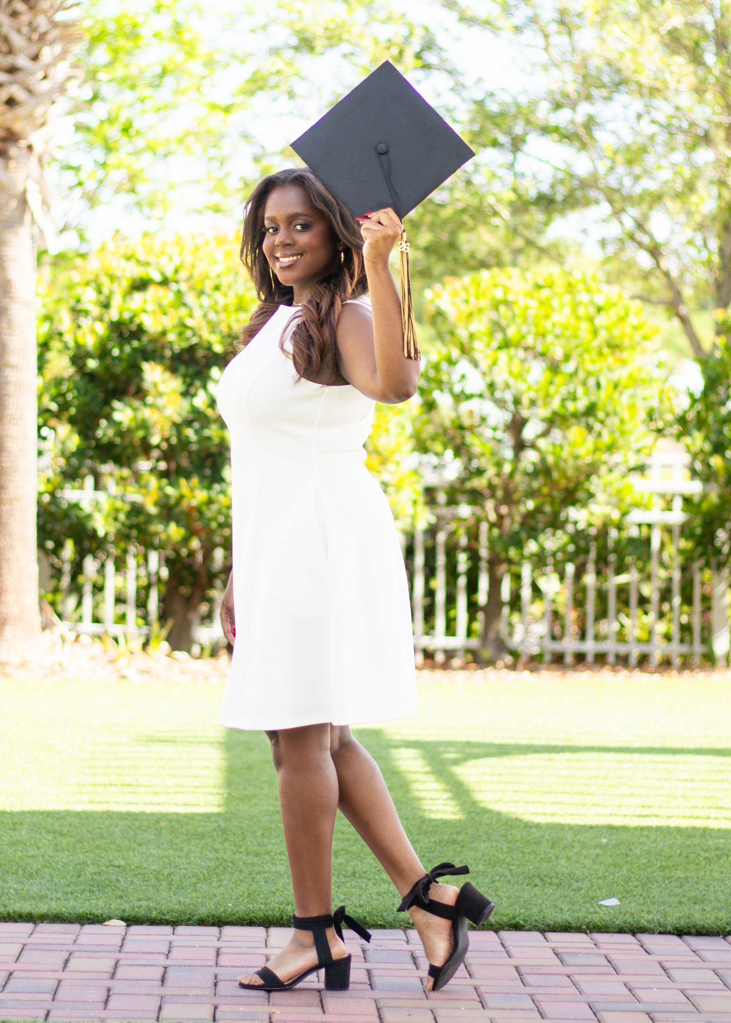 High school senior posing with her graduation cap during an outdoor senior photography session