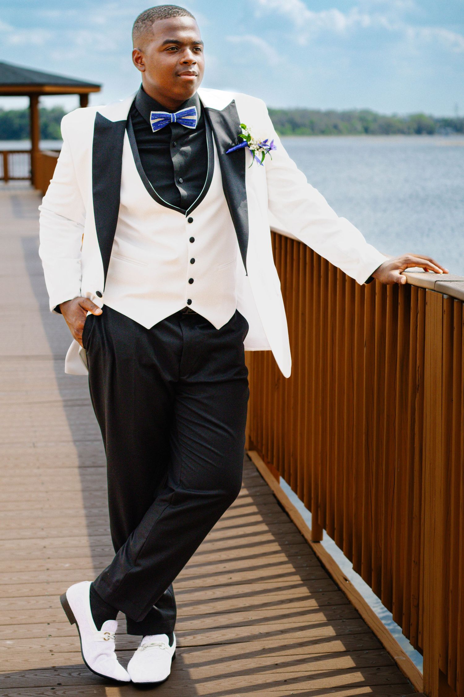 High school senior boy posing on a dock for prom photos during an outdoor photography session