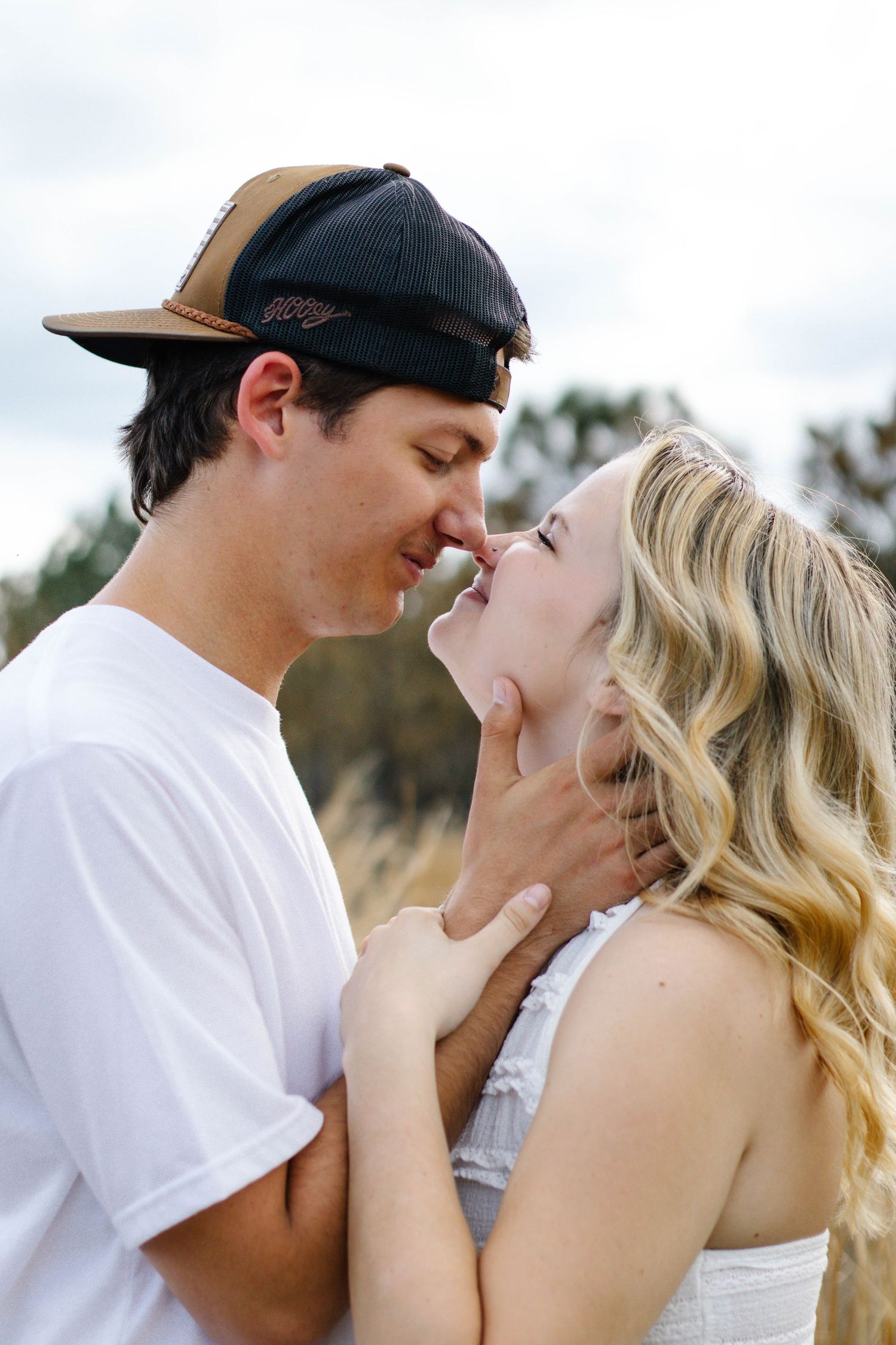 Couple holding each other’s faces closely during an intimate outdoor photography session