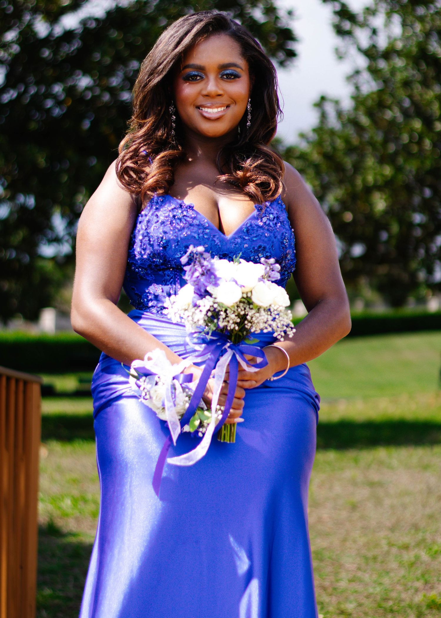 High school senior girl posing on stairs in her prom dress during an outdoor photography session