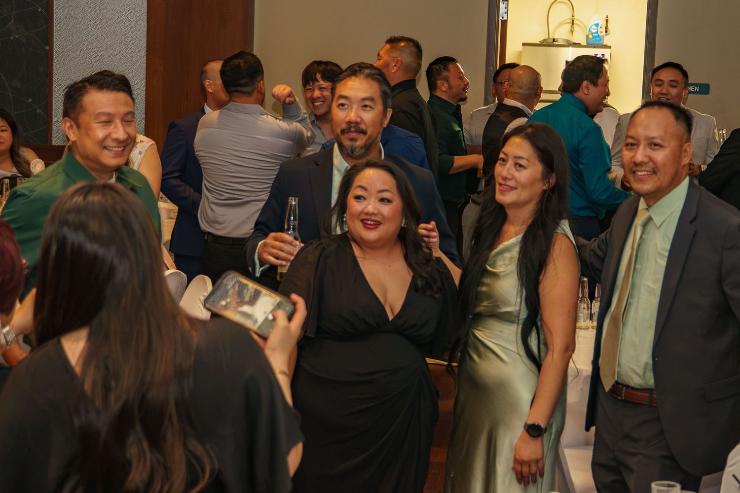 Group of Asian adults posing for photos at an elegant formal event or gala dinner celebration.