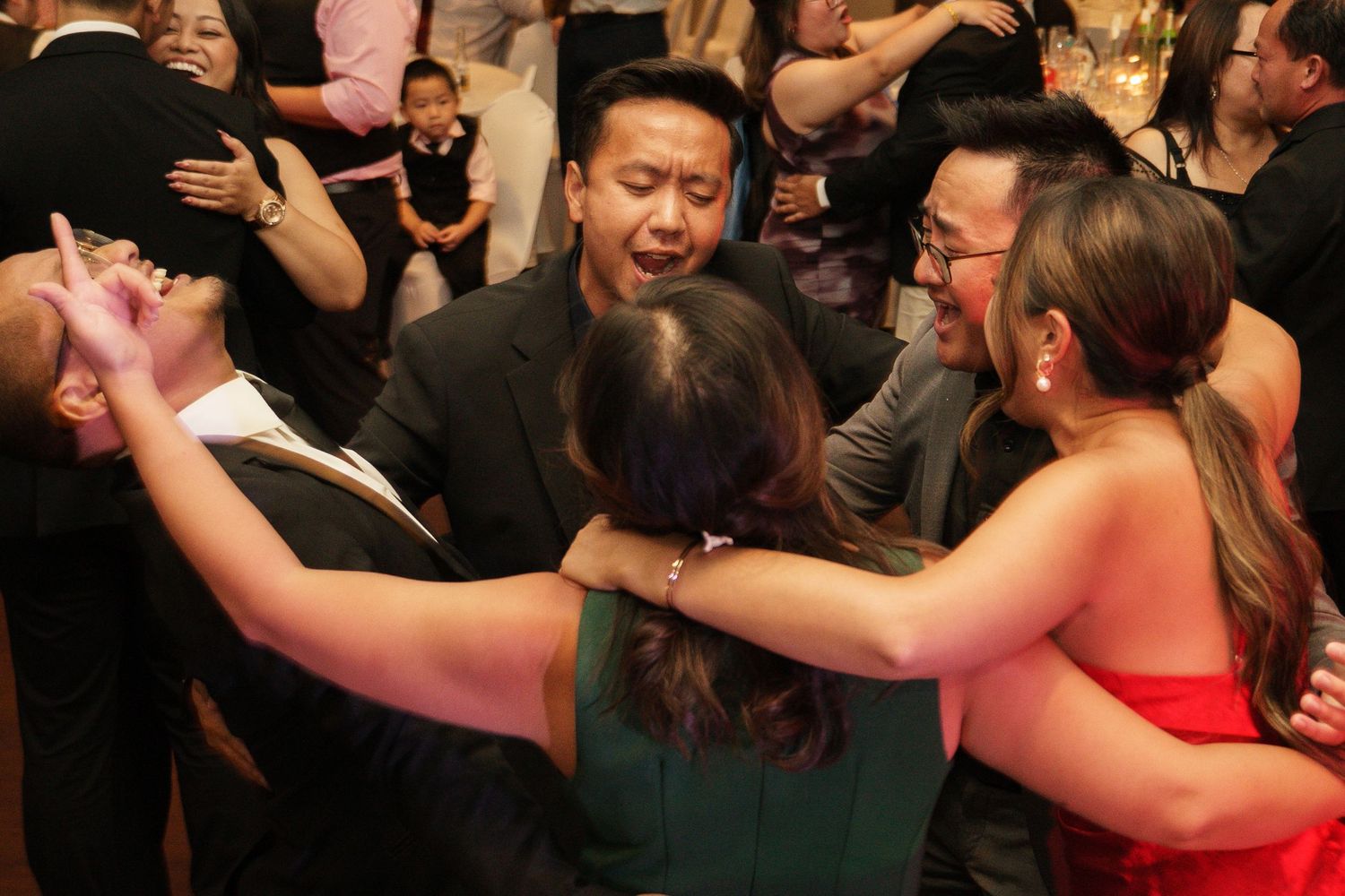 Guests dancing and celebrating joyfully at a formal wedding reception party.