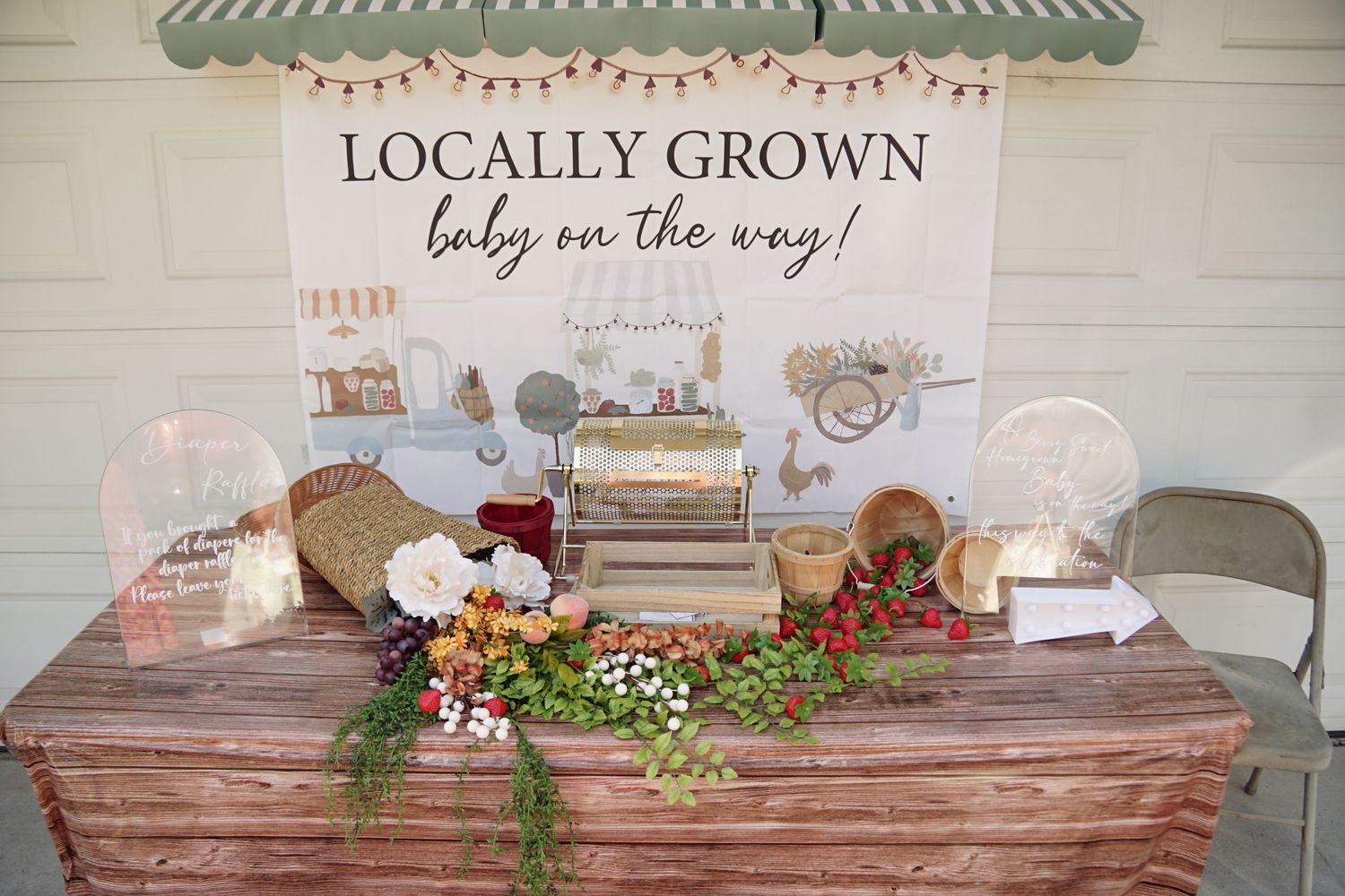 Rustic baby shower table with locally grown theme, featuring fresh flowers, greenery, and farmhouse-style decorations.