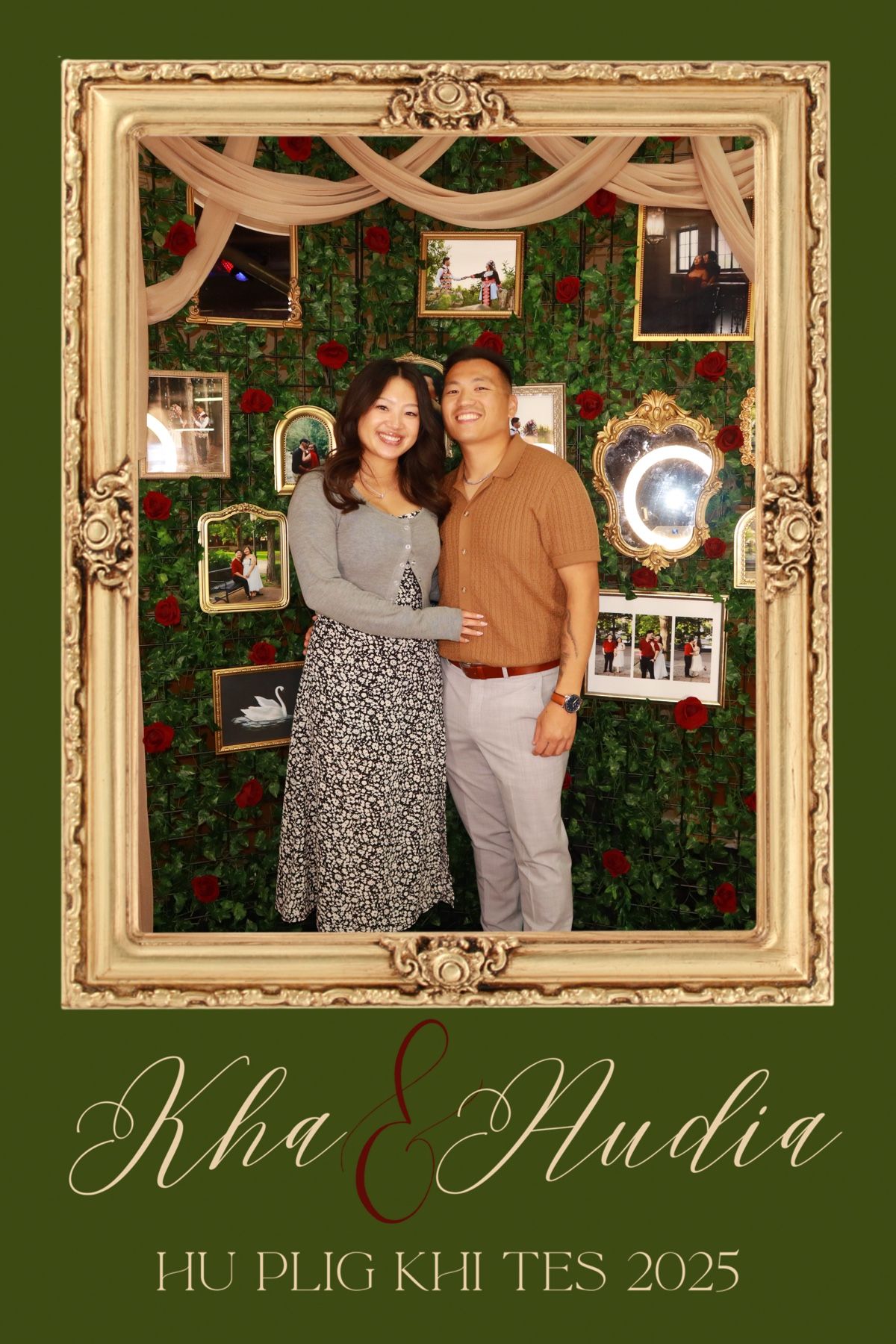 Couple smiles in wedding photo booth with green floral wall and gold frames at Kha & Nudia Hu Plig Khi Tes 2025.