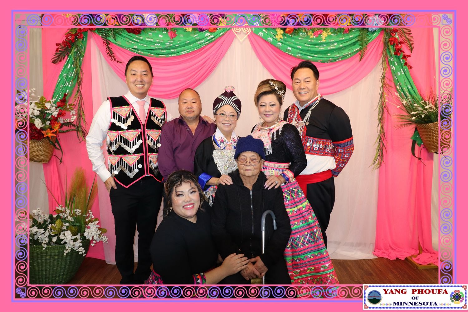 Group of people in traditional Hmong attire posing together at a festive event in Minnesota.