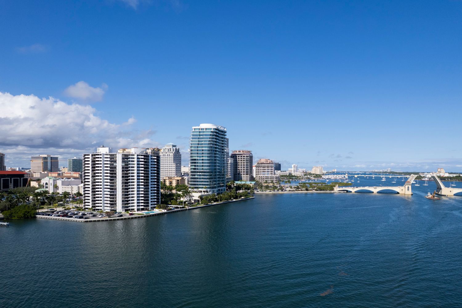 Palm Beach Real Estate aerial views of Scenic aerial view of West Palm Beach skyline with luxury condos, bridge, and Intracoastal Waterway.