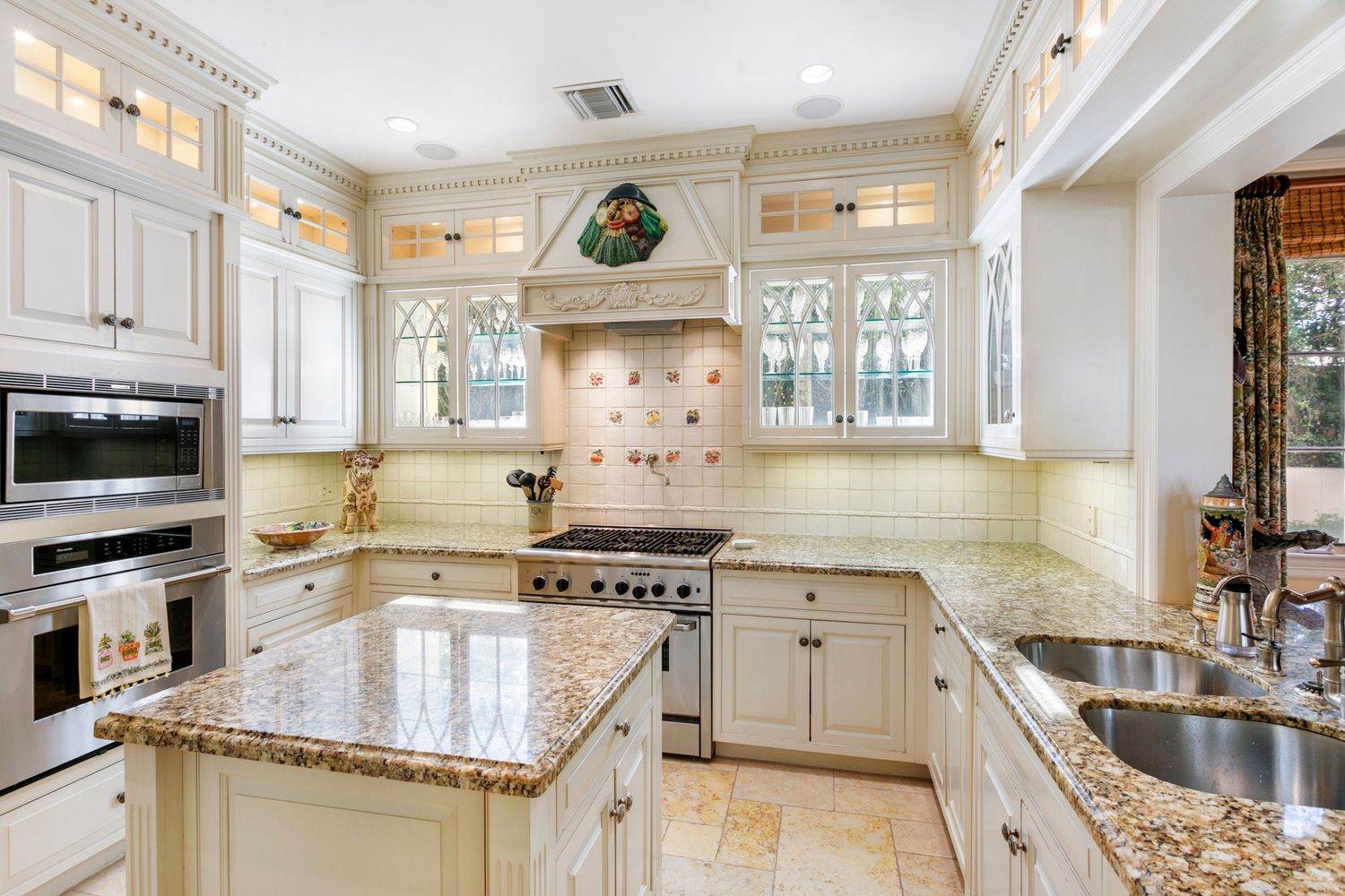 Elegant white kitchen with granite countertops, glass-front cabinets, stainless Professional real estate photography in Palm Bech, Florida