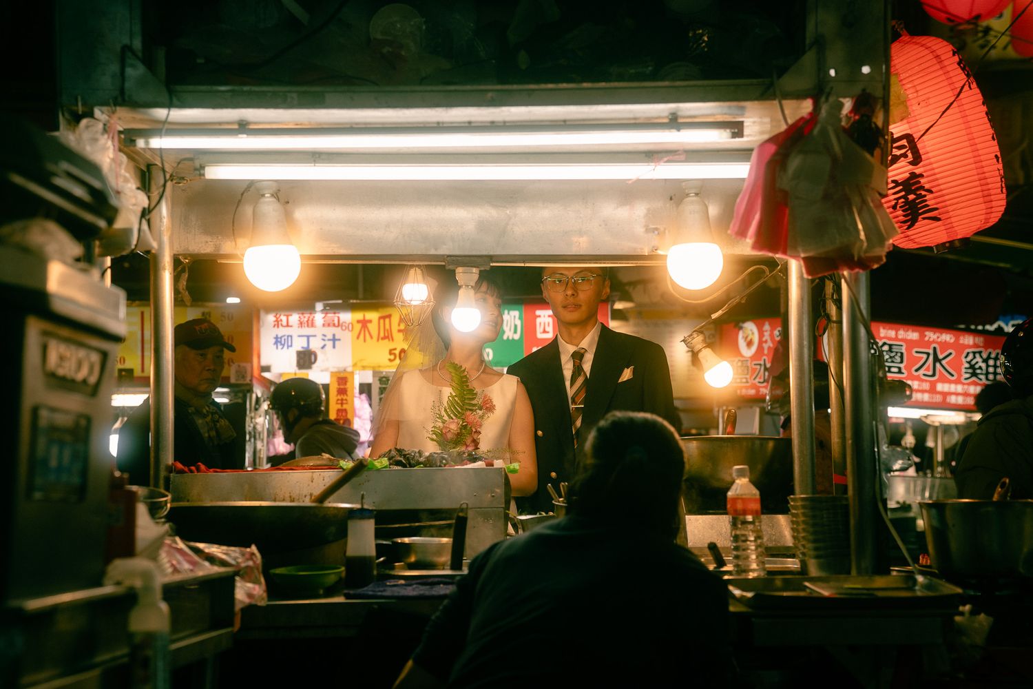 Couple in Night market in Los Angeles for a Hong Kong Style Photoshoot wearing wedding outfits