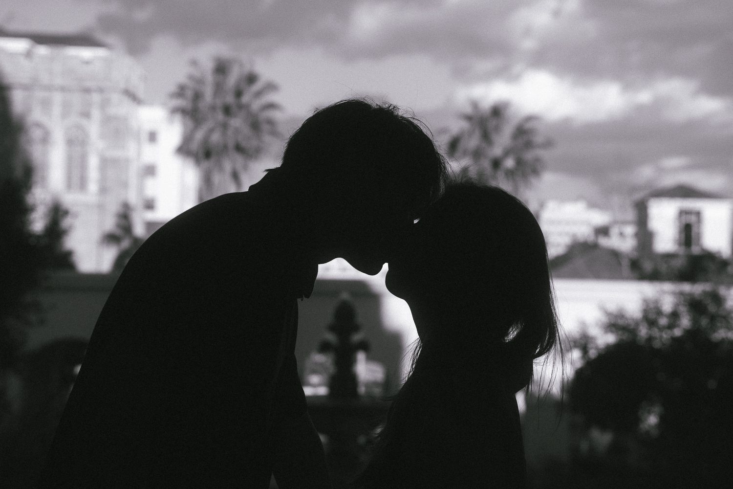 Silhouette of couple embracing under the arches at Pasadena City Hall.