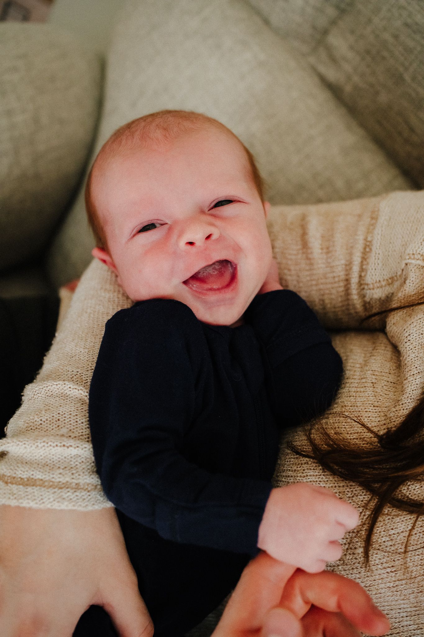 A series of close-up shots showing a baby in a navy blue outfit smiling and making expressions.