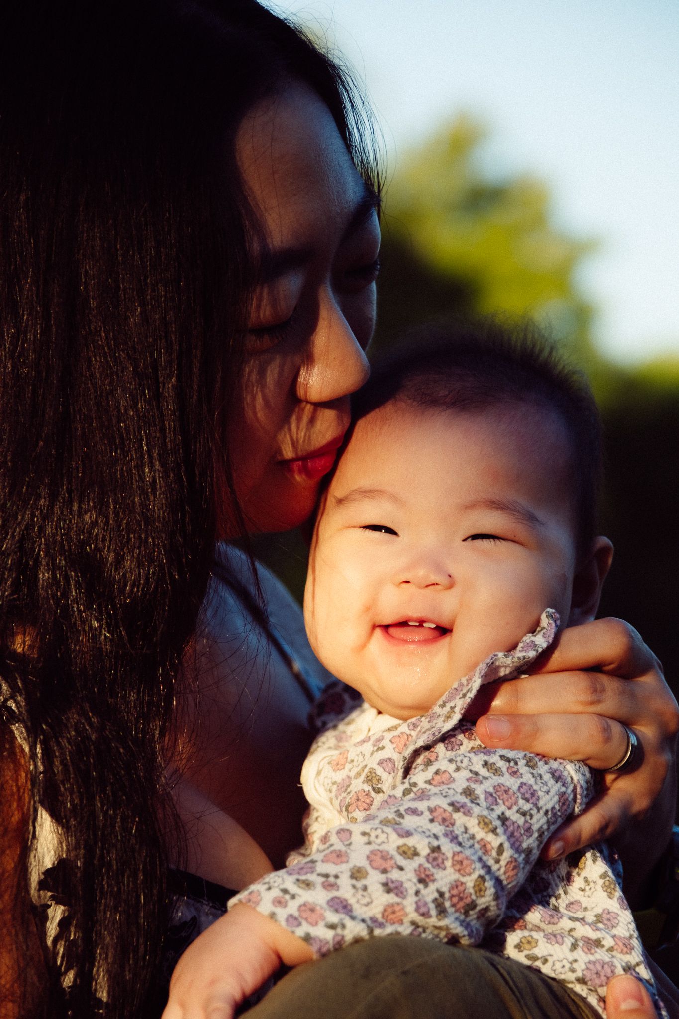 A tender moment between parent and child playing together outdoors in natural lighting.