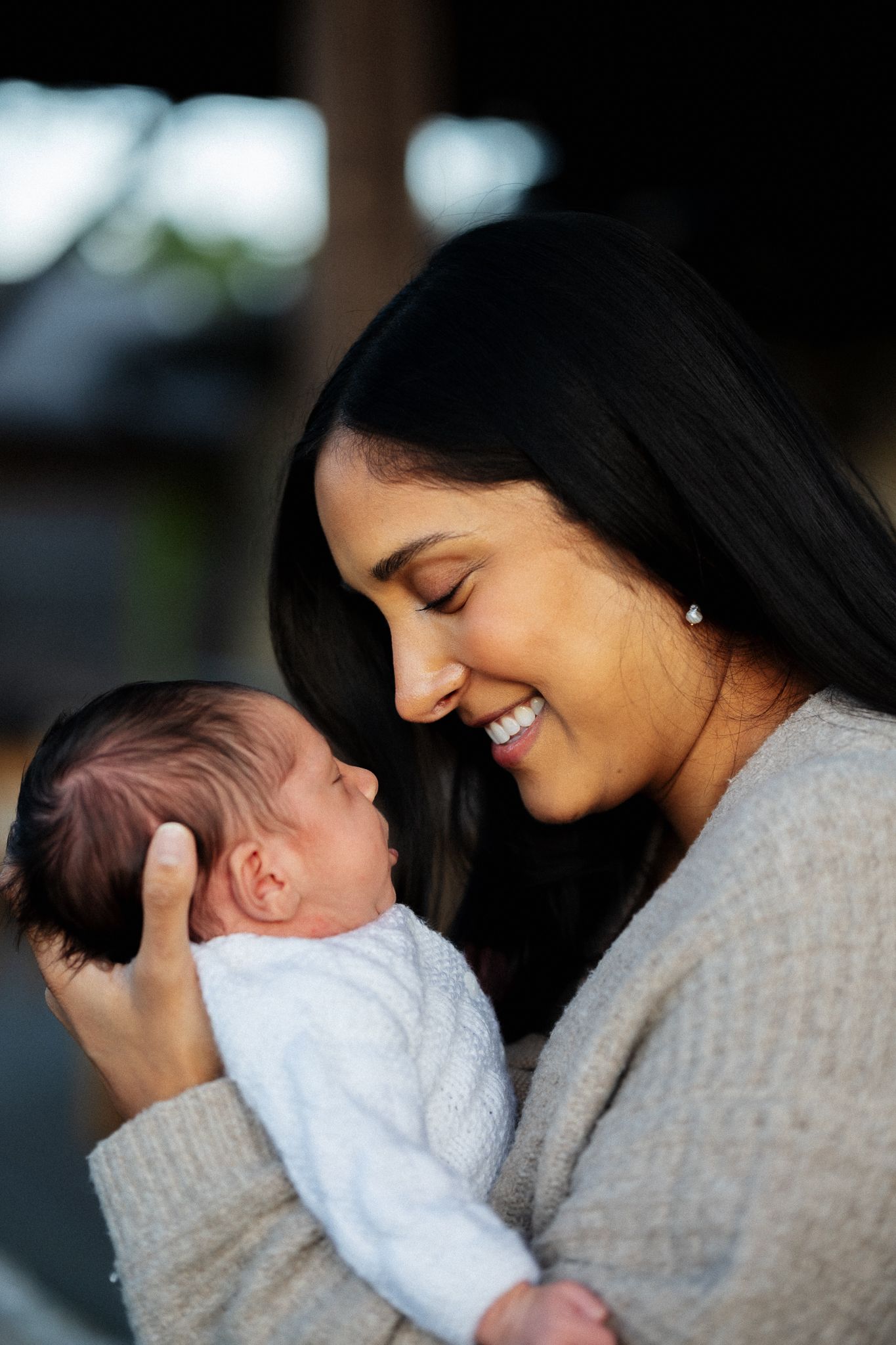 A tender moment between a parent and baby in soft natural lighting.