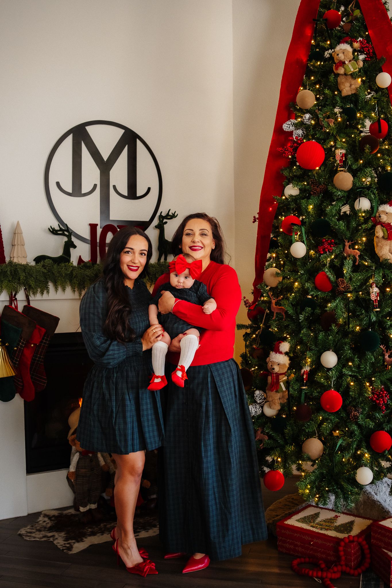 A series of festive holiday photos showing playful poses in front of decorated Christmas trees with red and white ornaments.
