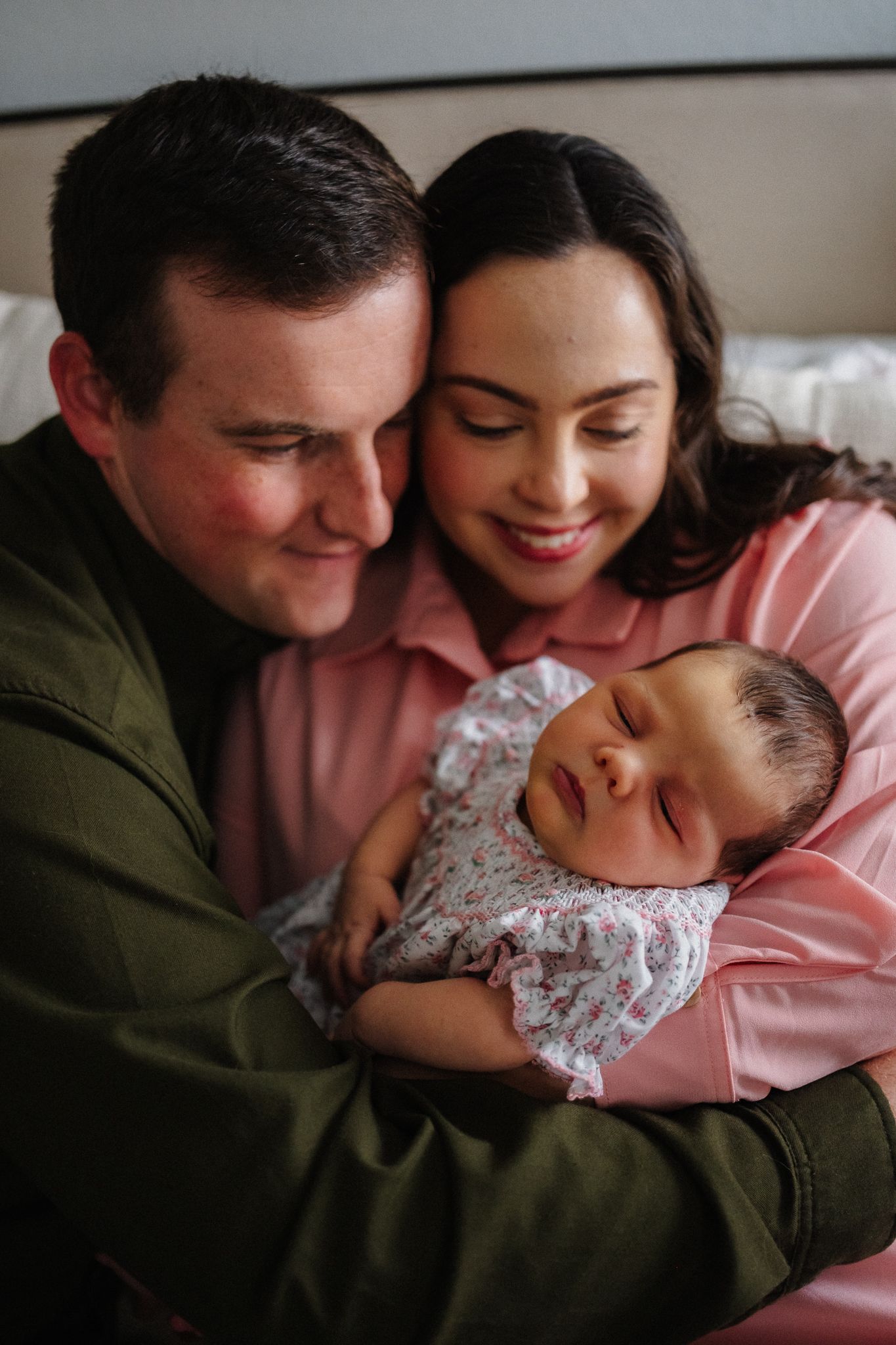 A couple holds and cuddles with their newborn baby in a series of intimate family portraits.
