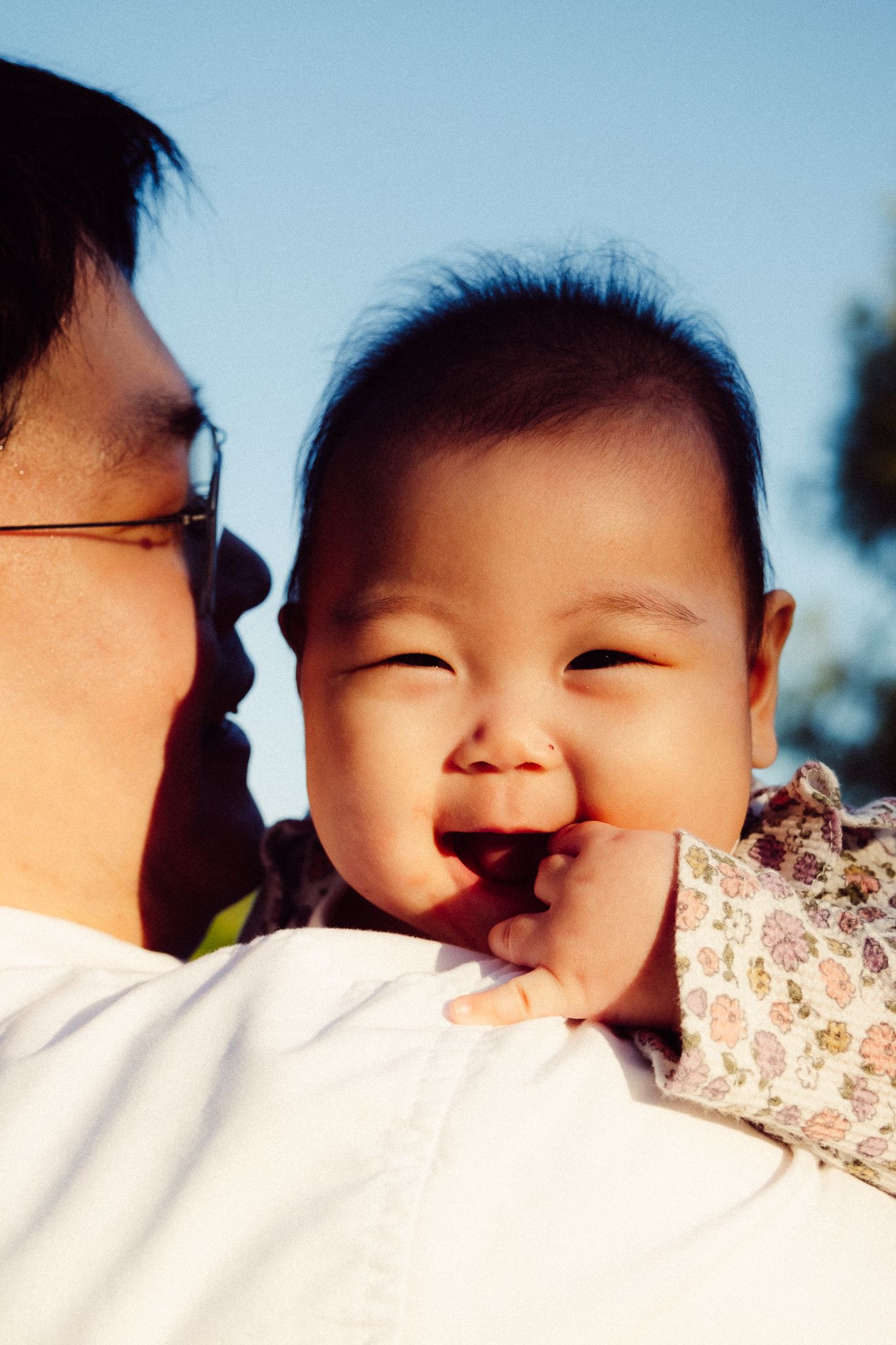 A joyful moment captured in warm sunlight showing a tender interaction outdoors.