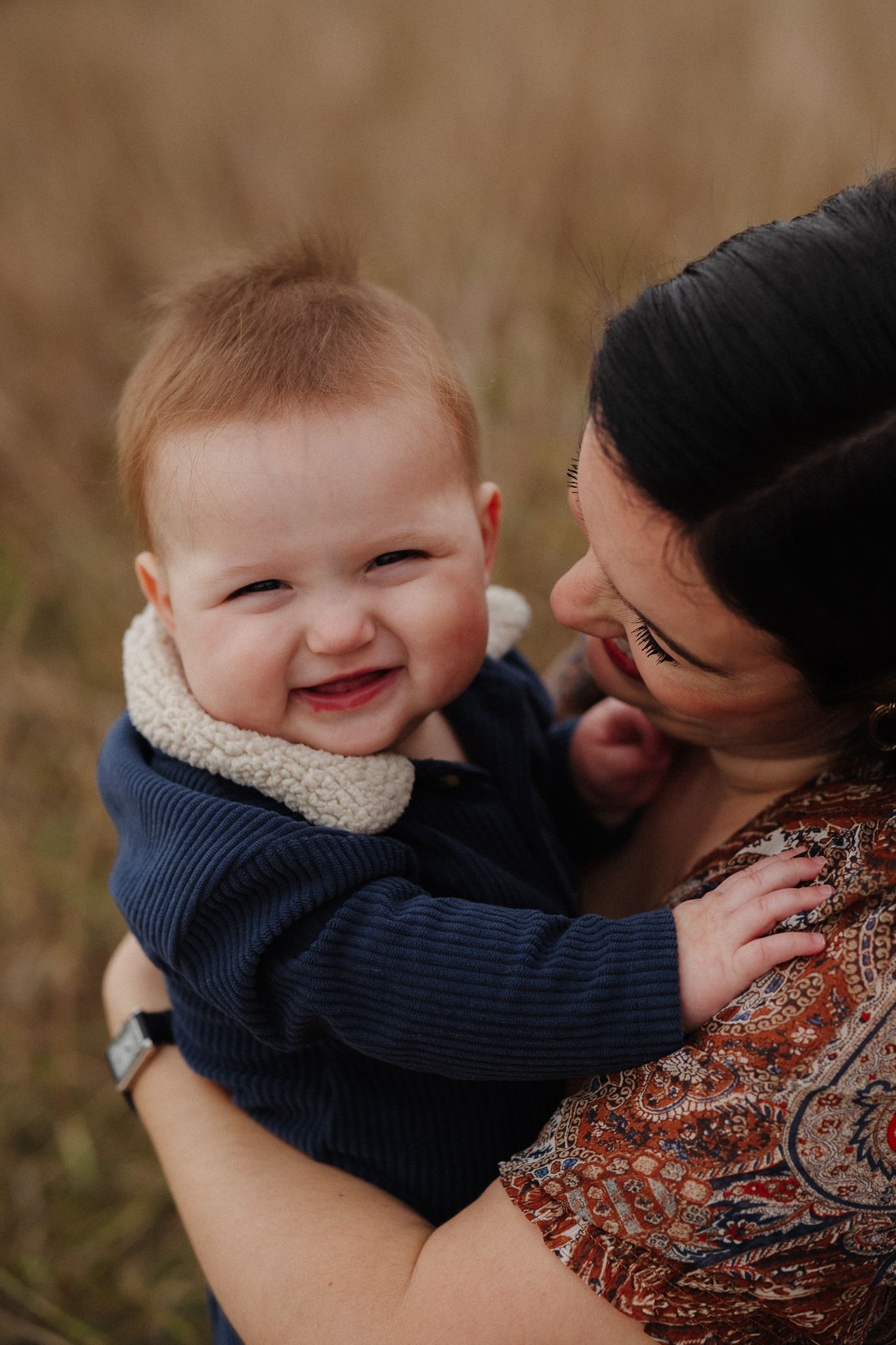 A series of candid shots showing tender moments between a baby in navy blue and caregiver against a blurred background.