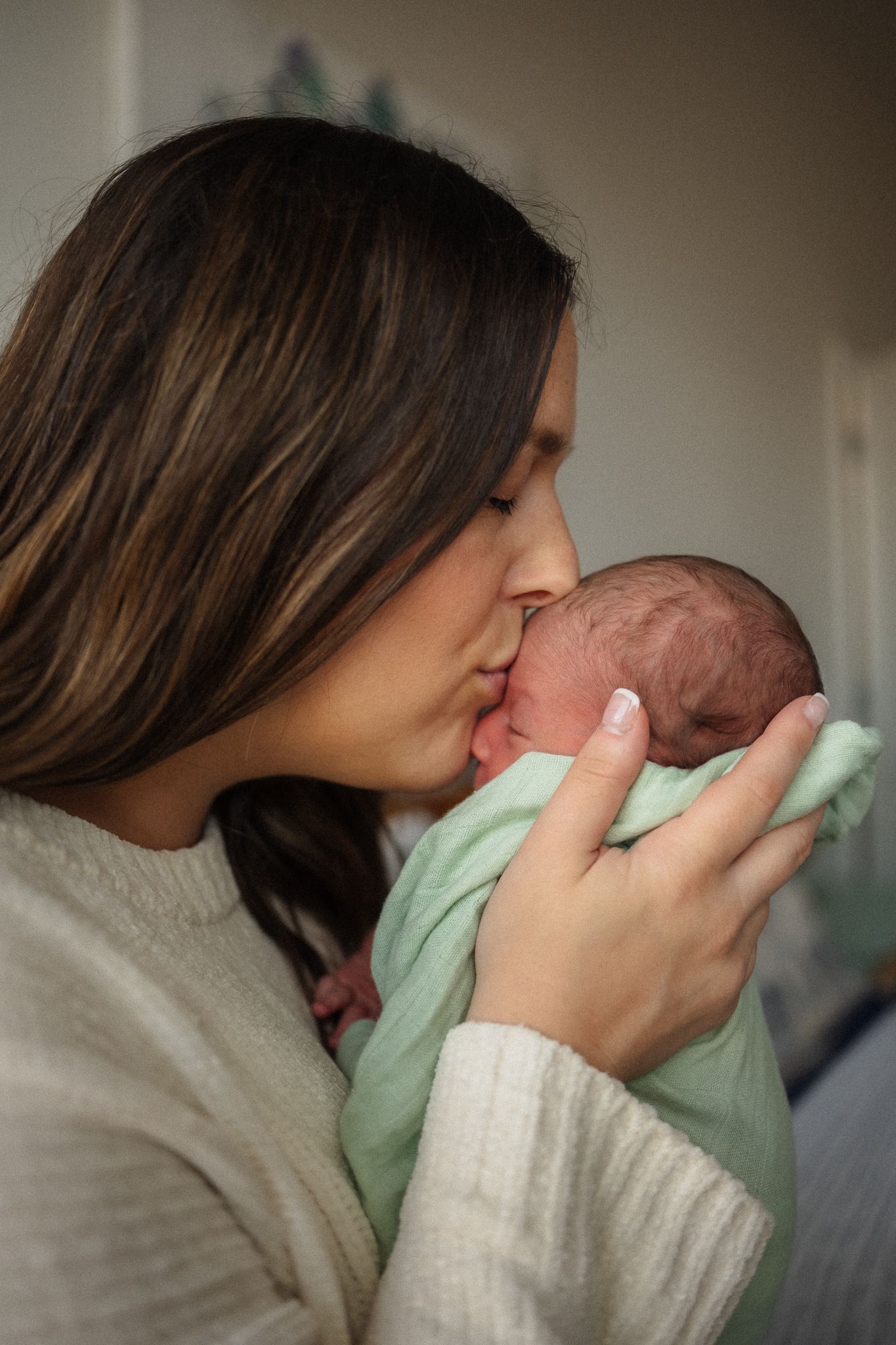 A sequence of photos showing a tender moment between a parent and infant in soft, muted lighting.