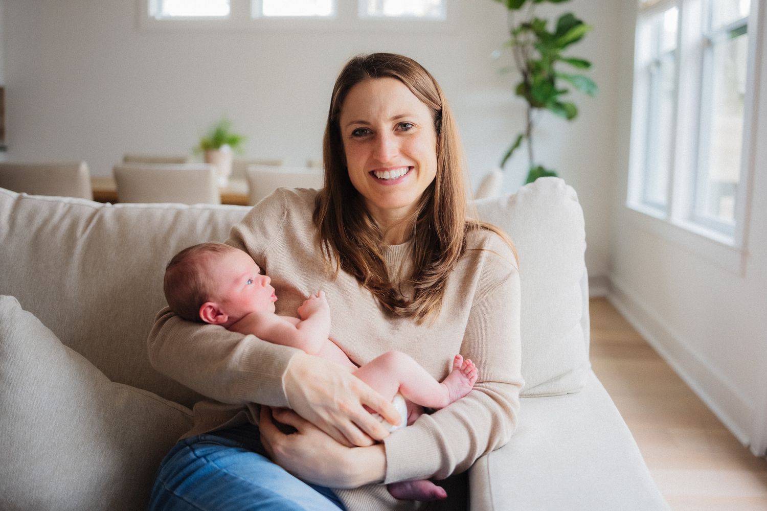 A collection of lifestyle photos showing tender moments between parent and baby in a bright, modern living room.