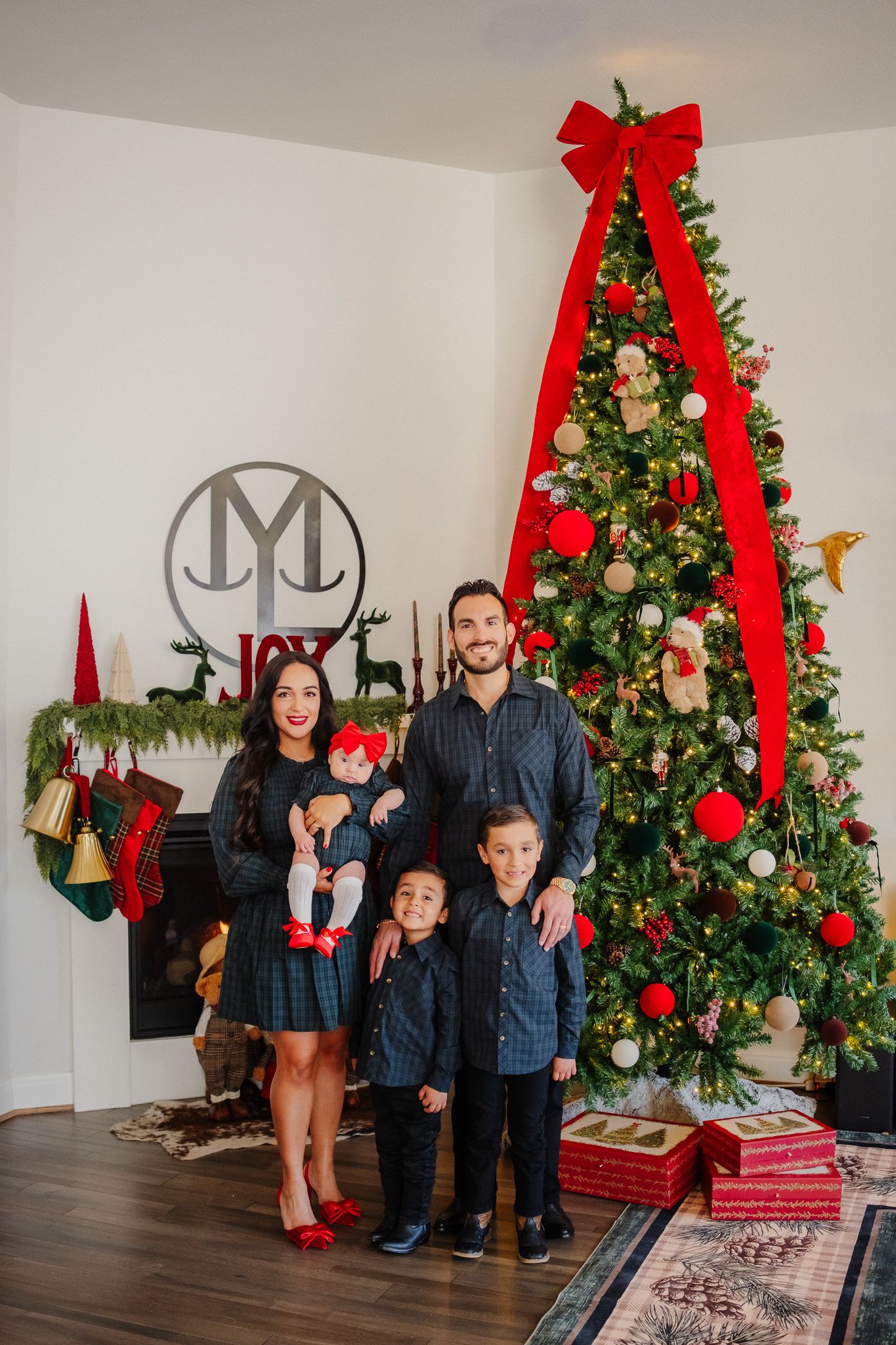 A beautifully decorated Christmas scene with a large tree adorned with red bows and white ornaments.