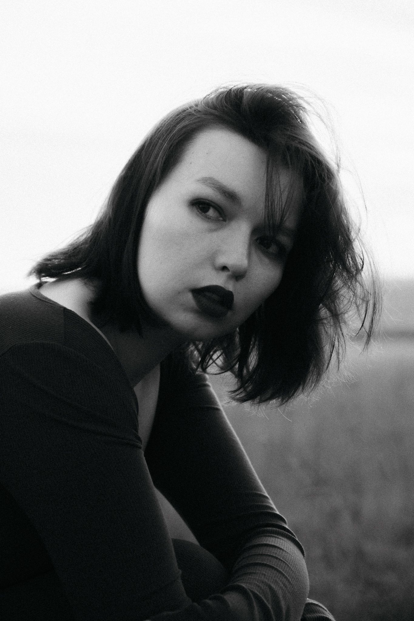 Black and white portrait series showcasing moody expressions and dynamic angles in a natural setting.