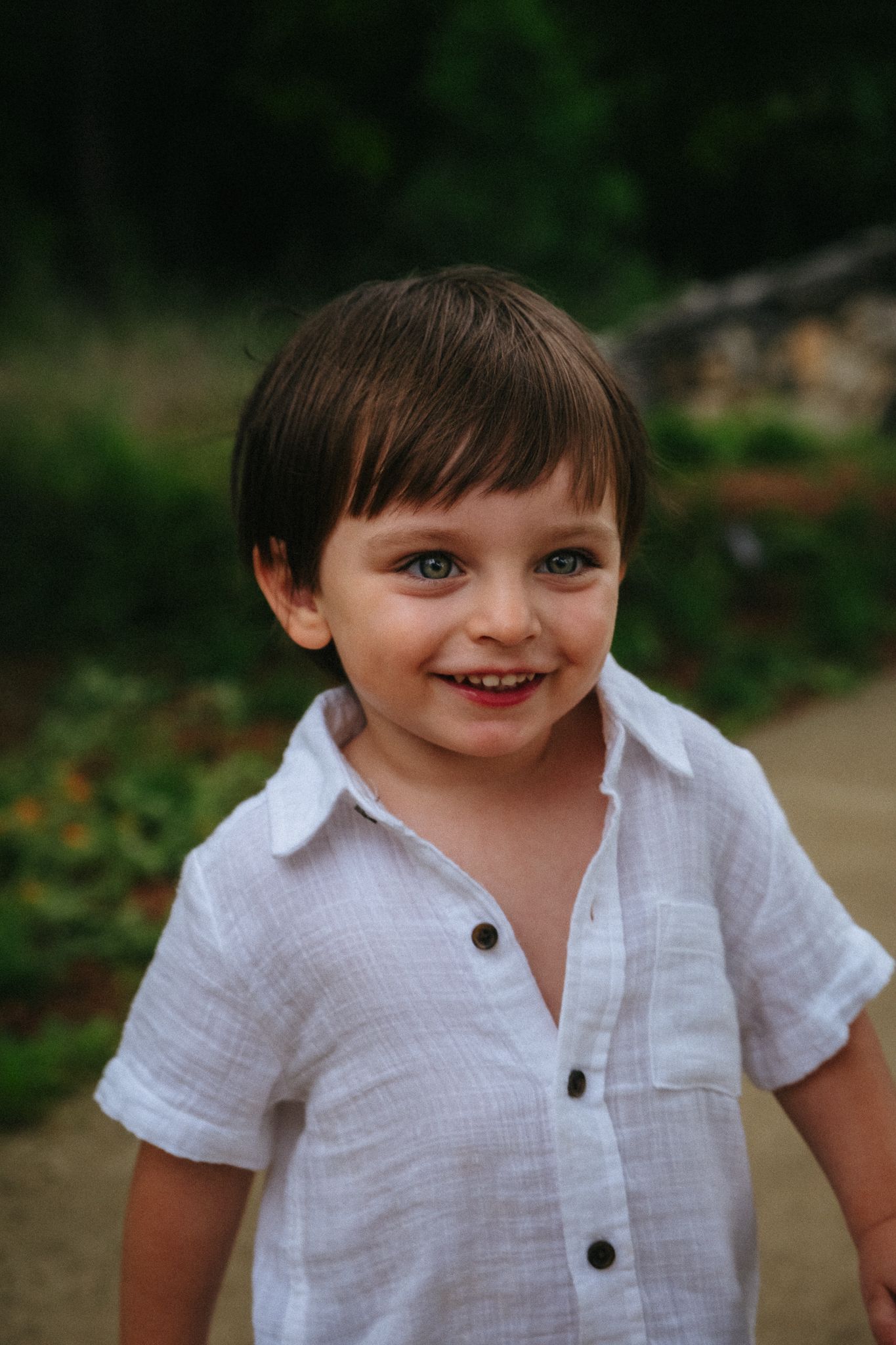 Five sequential images show a playful young child in a white button-up shirt expressing various cheerful emotions.