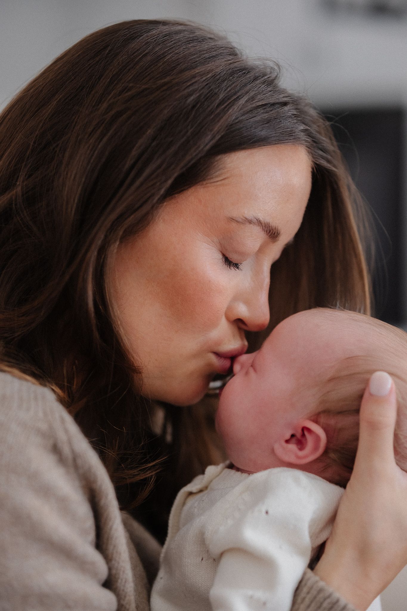 Intimate close-up photos show gentle moments between parent and newborn.