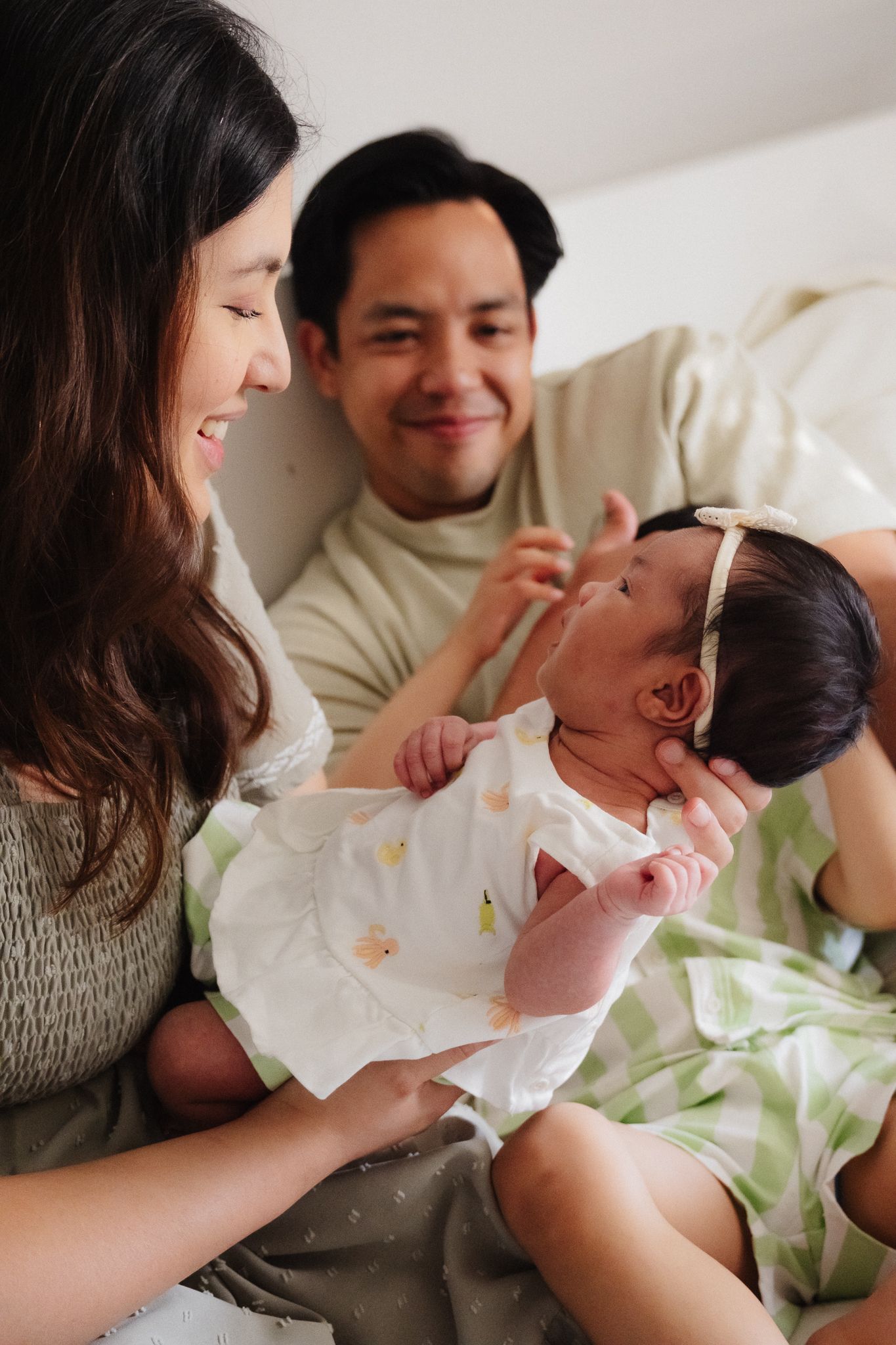 A happy family shares a tender moment with their baby while relaxing together at home.
