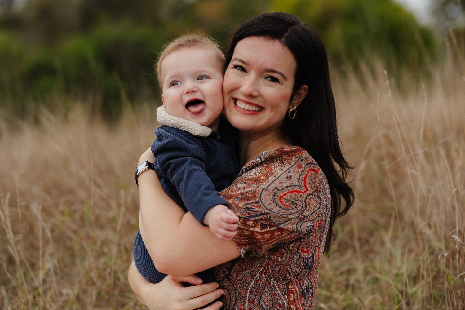 Mother and child share joyful moments together in a golden field at sunset.