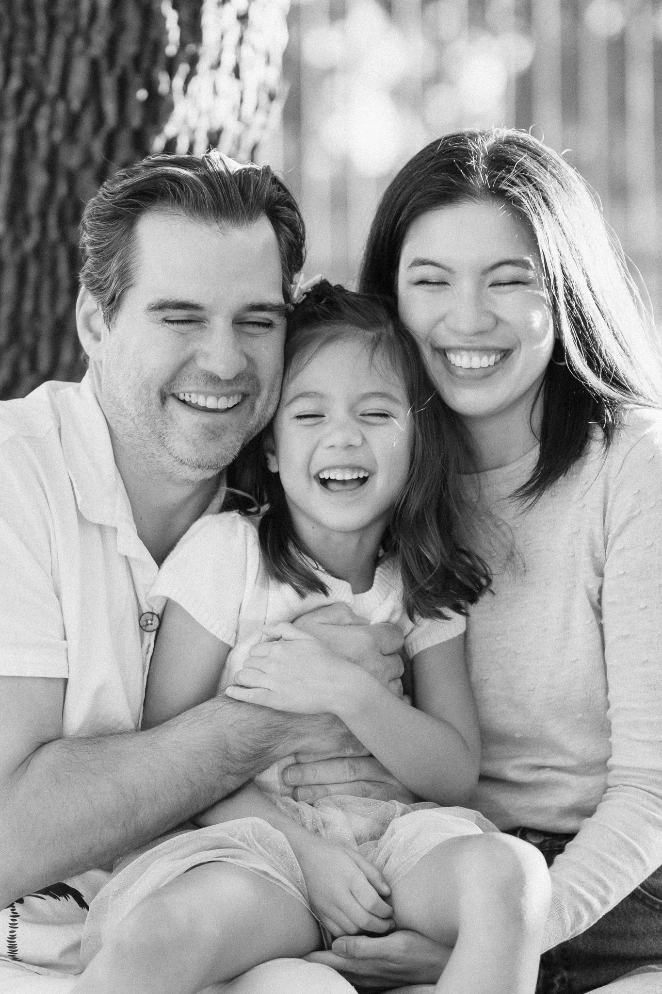 Black and white candid family portraits showing joyful expressions and laughter.