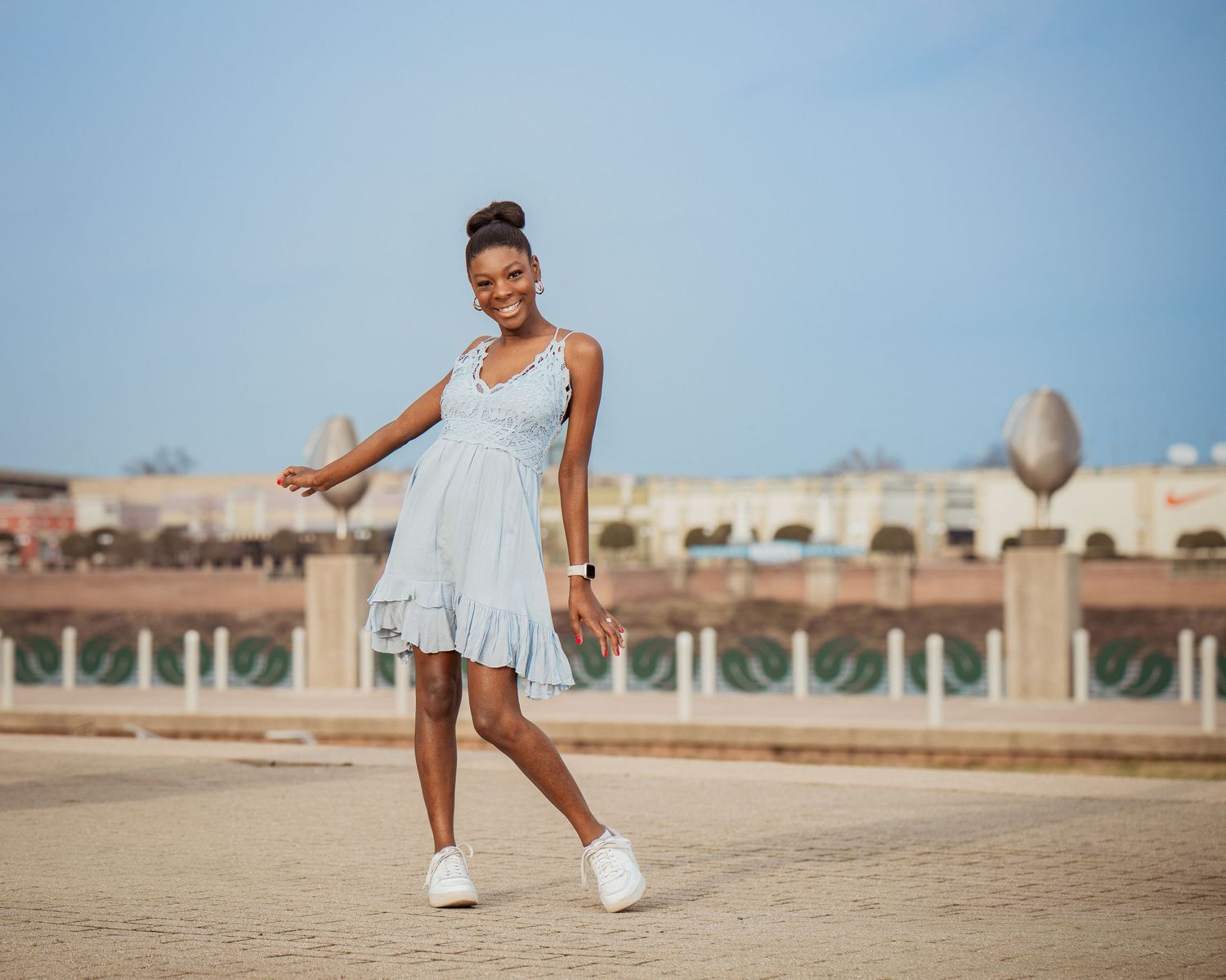 A person in white clothing performs a series of dynamic dance movements at a beachfront arcade.