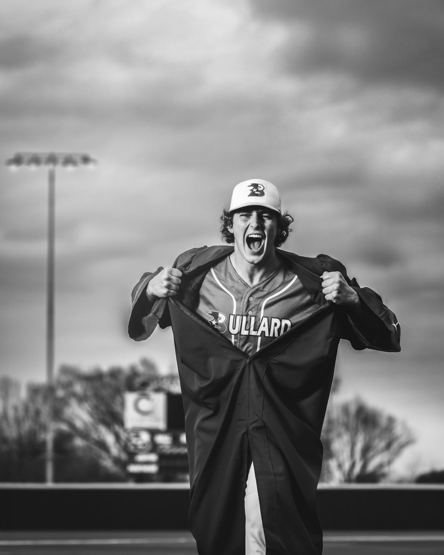 A monochrome shot shows an athlete in a Bullard jersey displaying intense emotion at a sports venue.