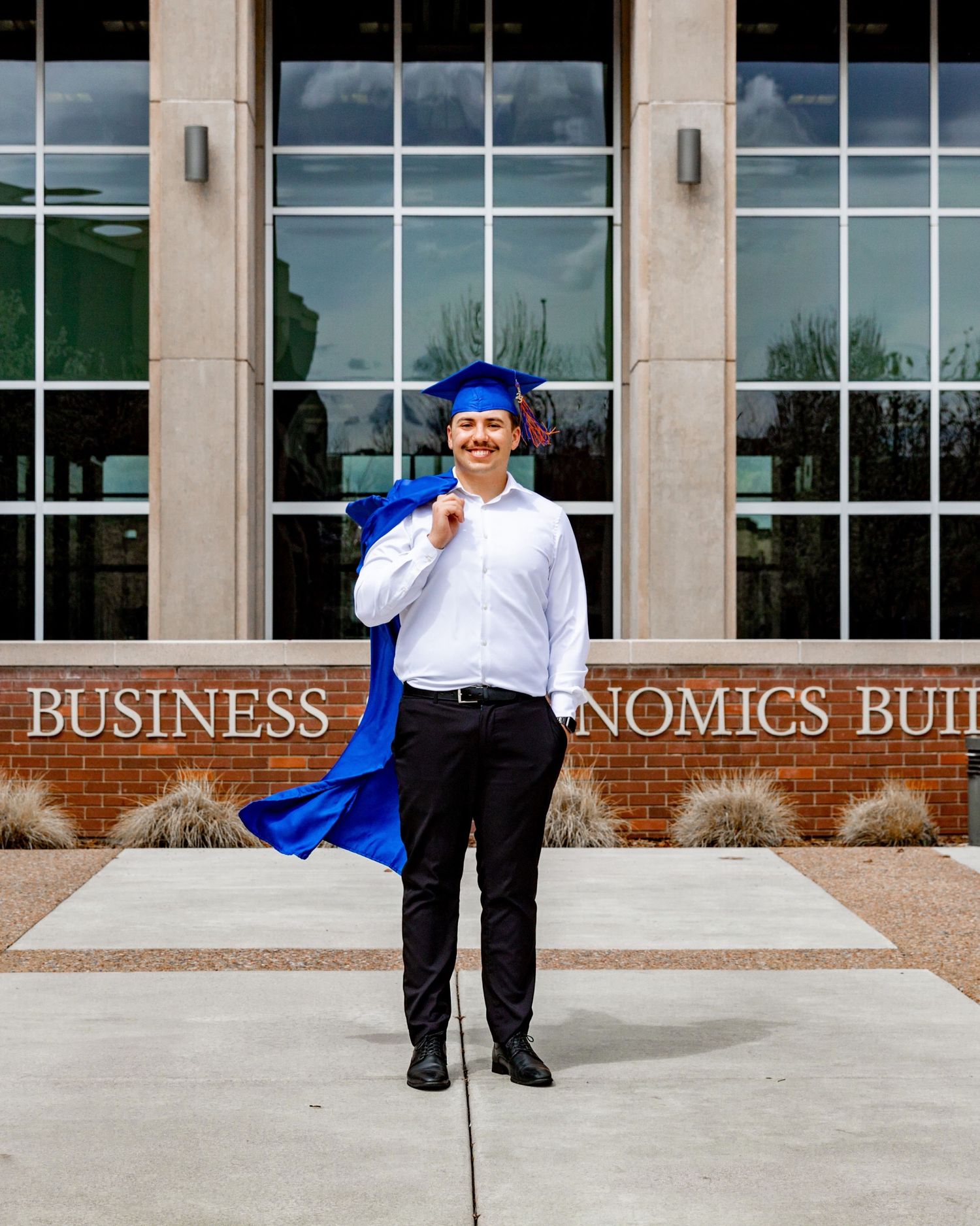 a grad posing in front of a sign