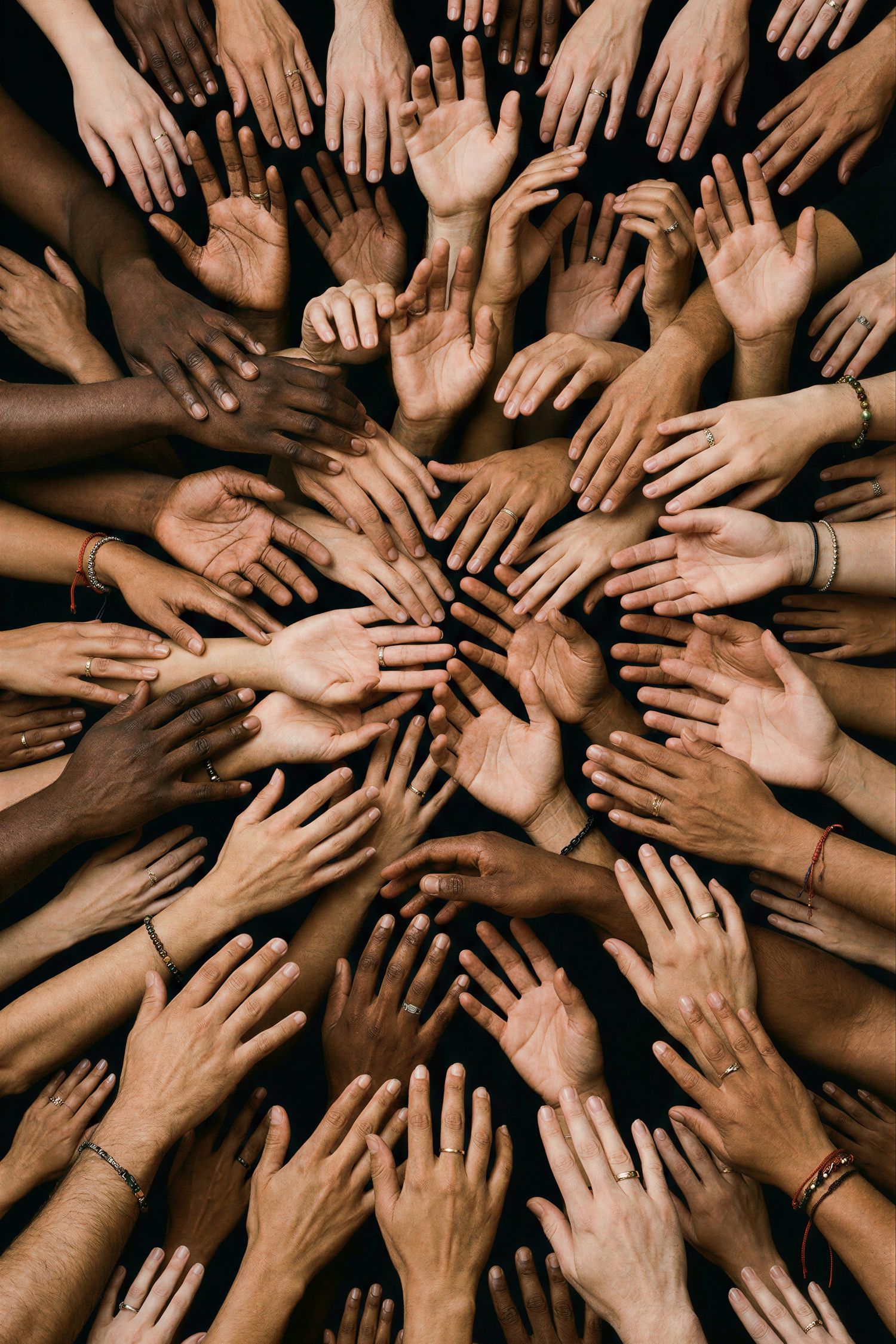 Diverse hands of many skin tones arranged in a circular pattern together.