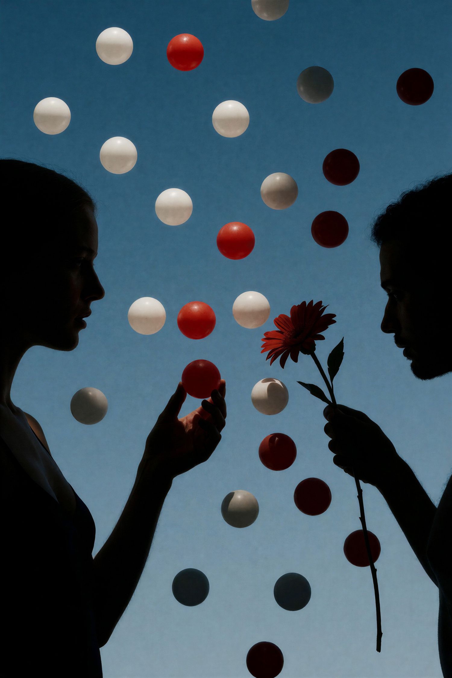 Two silhouettes facing each other with colorful spheres floating in blue sky.