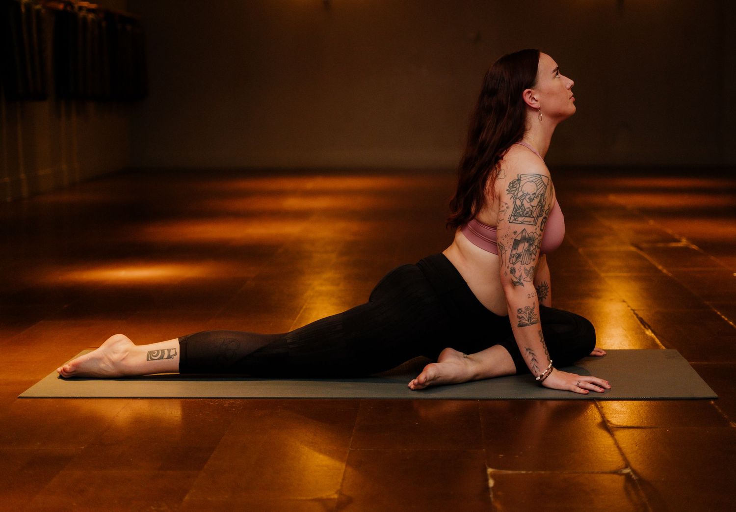 A sequence of yoga poses performed on a mat in a dimly lit room with warm ambient lighting.