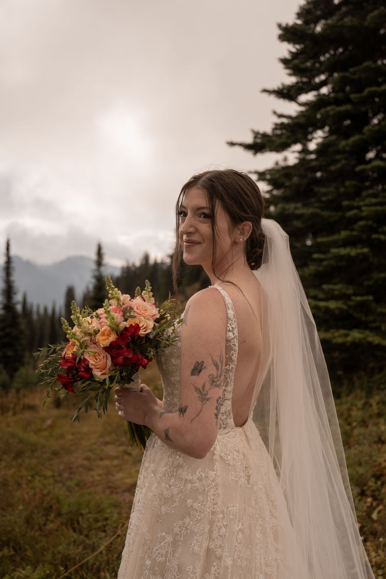 A bride holds her bouquet on her elopement day in the forest.