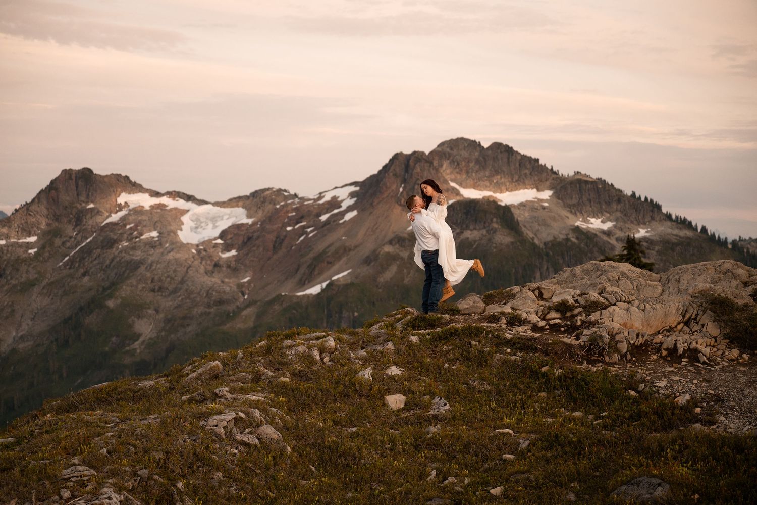 A couple celebrates their engagement on a mountain ridge near Mt. Baker in Washington State.