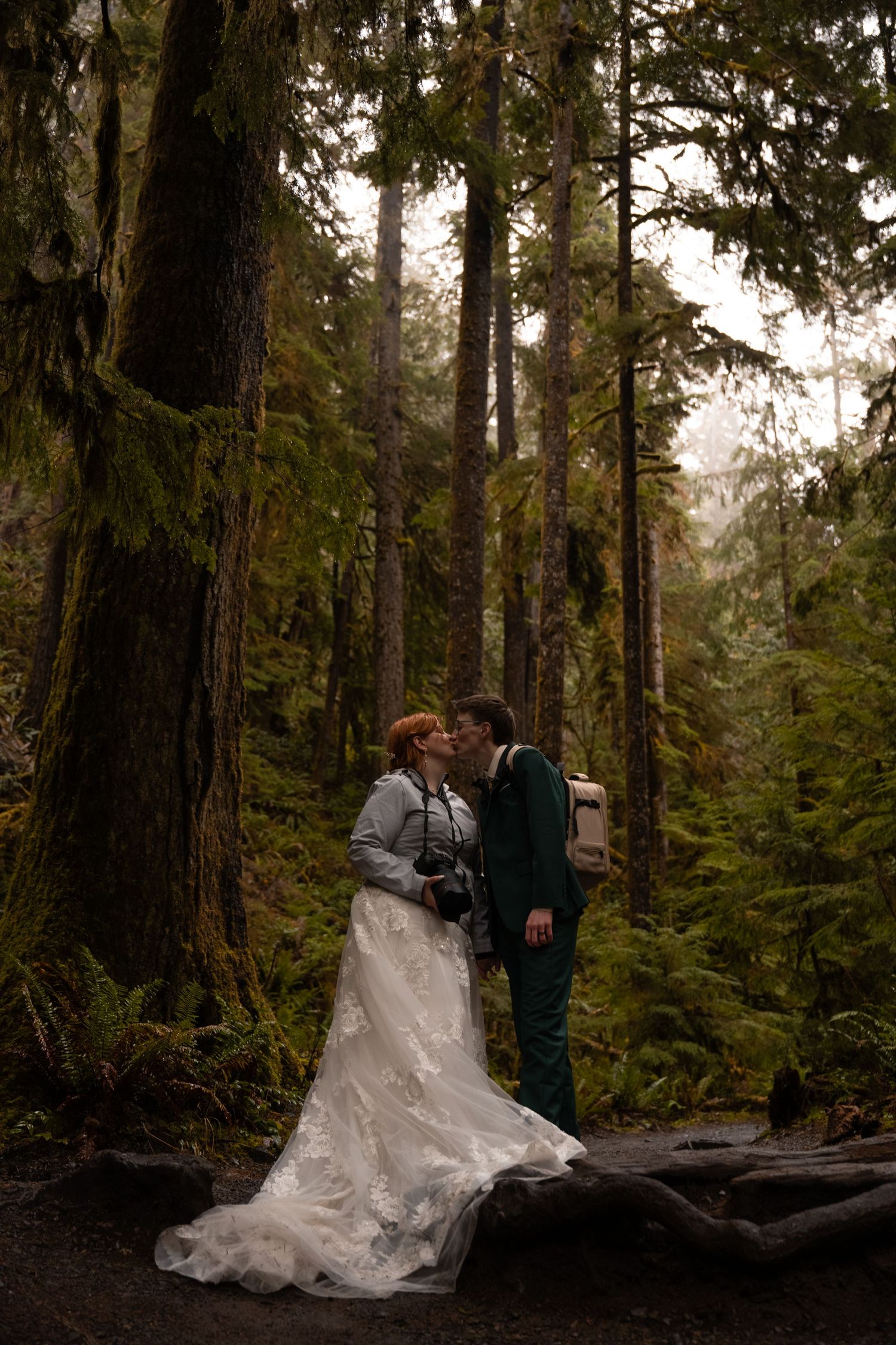 A queer couple pauses for a kiss on their hiking adventure elopement.