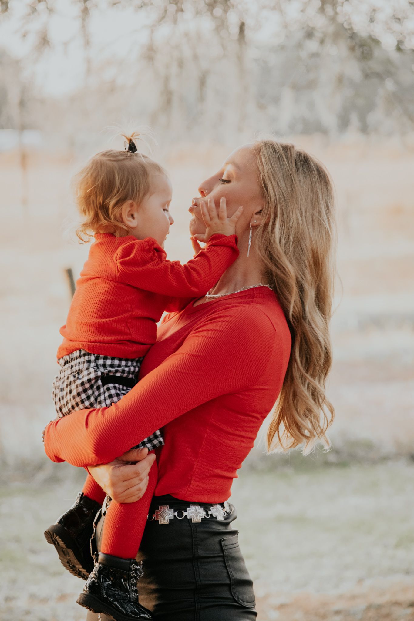 A mother and daughter share a sweet kiss during a Christmas family session.