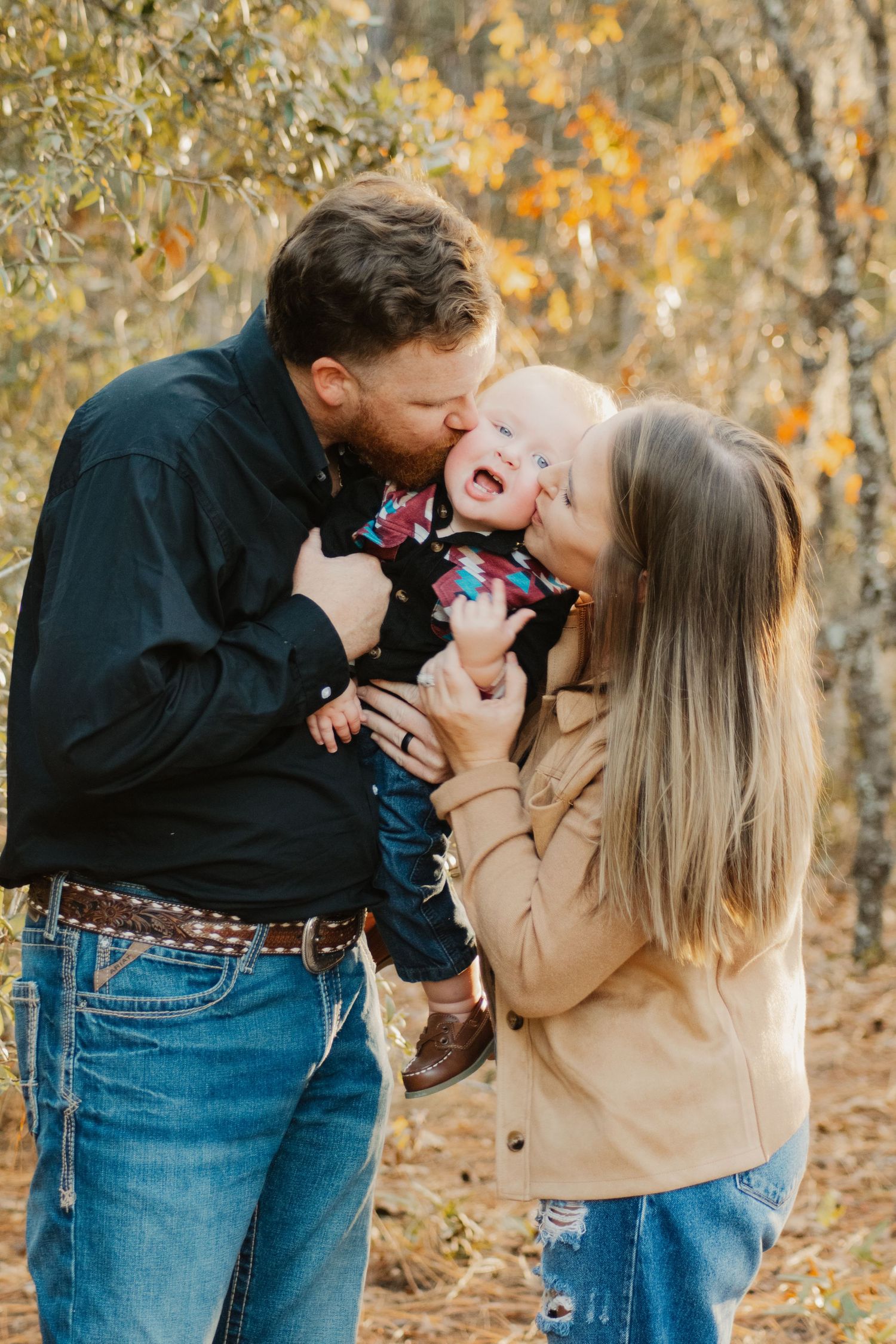 A loving family shares joyful moments together outdoors during autumn with golden foliage in the background.